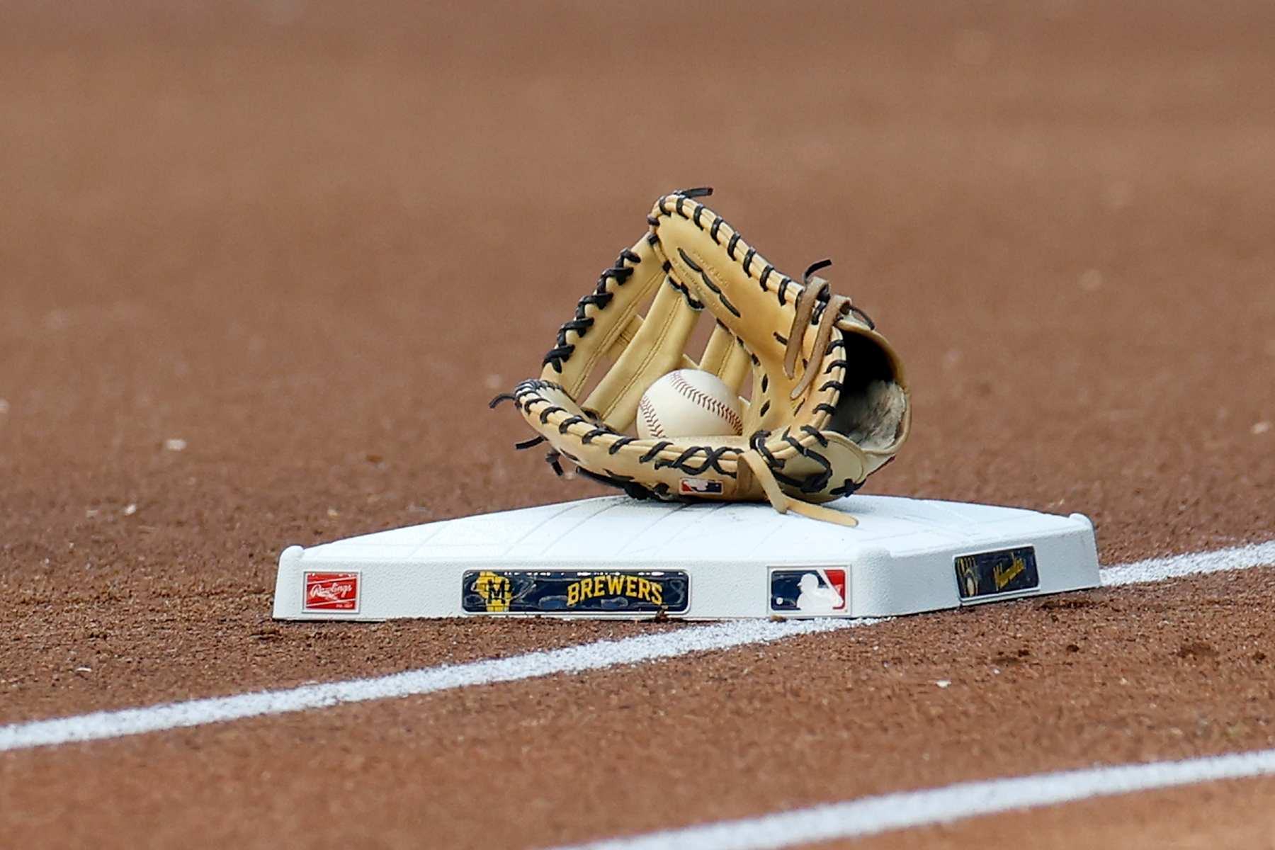 MILWAUKEE, WISCONSIN - SEPTEMBER 29: A picture of glove and ball on top of first base during the game between the Milwaukee Brewers vs New York Mets at American Family Field on September 29, 2024 in Milwaukee, Wisconsin. (Photo by John Fisher/Getty Images)