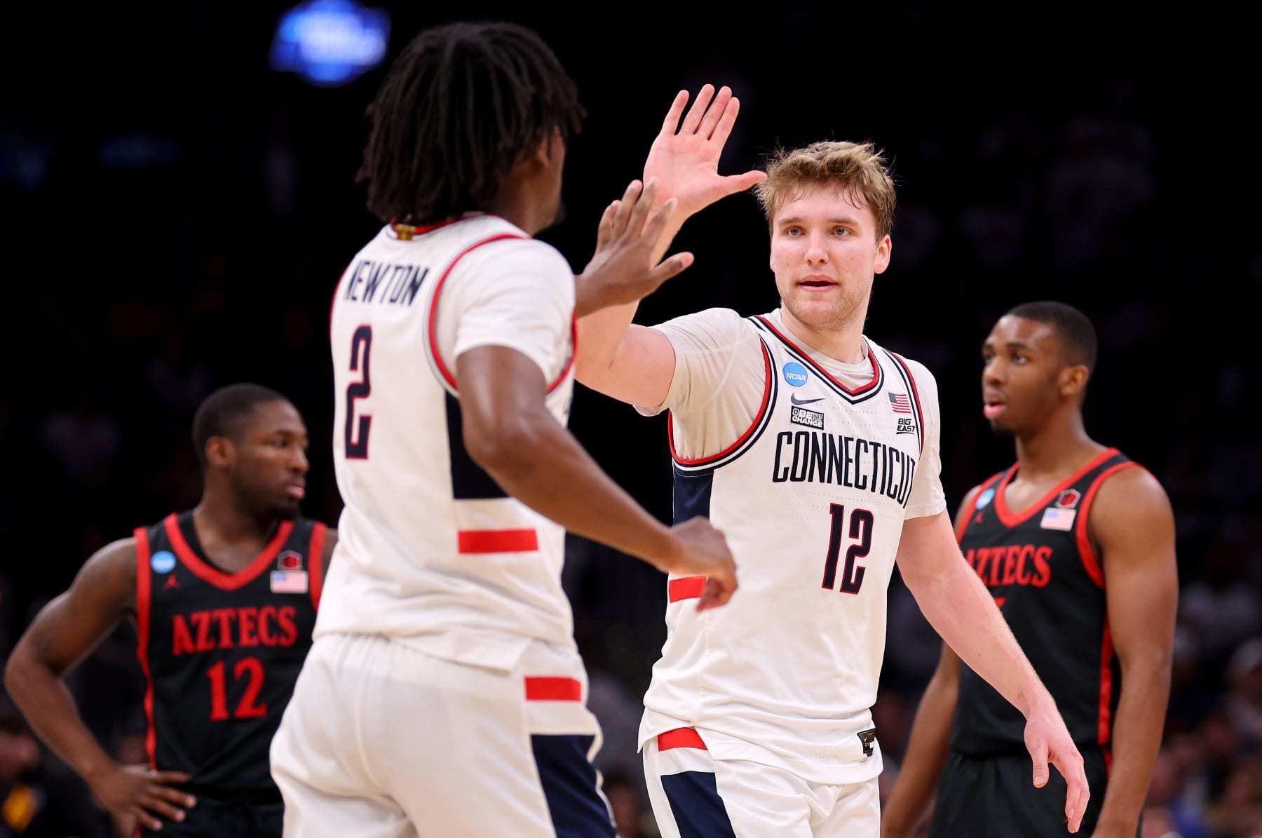BOSTON, MASSACHUSETTS - MARCH 28: Cam Spencer #12 and Tristen Newton #2 of the Connecticut Huskies high five against the San Diego State Aztecs during the second half in the Sweet 16 round of the NCAA Men's Basketball Tournament at TD Garden on March 28, 2024 in Boston, Massachusetts. (Photo by Michael Reaves/Getty Images)