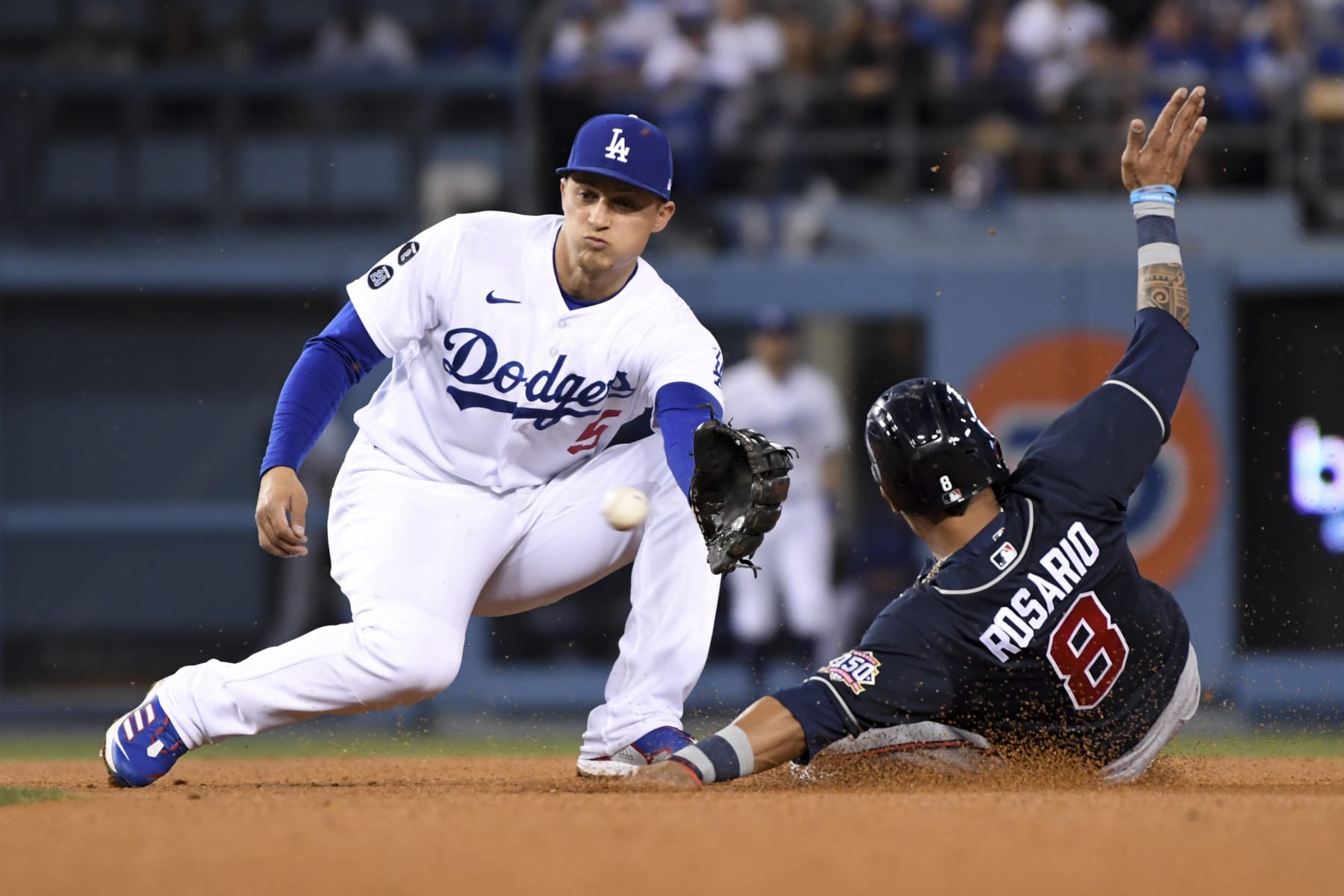 Los Angeles, CA - October 21: Los Angeles Dodgers shortstop Corey Seager, left, prepares to catch a ball while Atlanta Braves' Eddie Rosario attempts to steal second during the third inning in game five in the 2021 National League Championship Series at Dodger Stadium on Thursday, Oct. 21, 2021 in Los Angeles, CA. (Wally Skalij / Los Angeles Times via Getty Images)