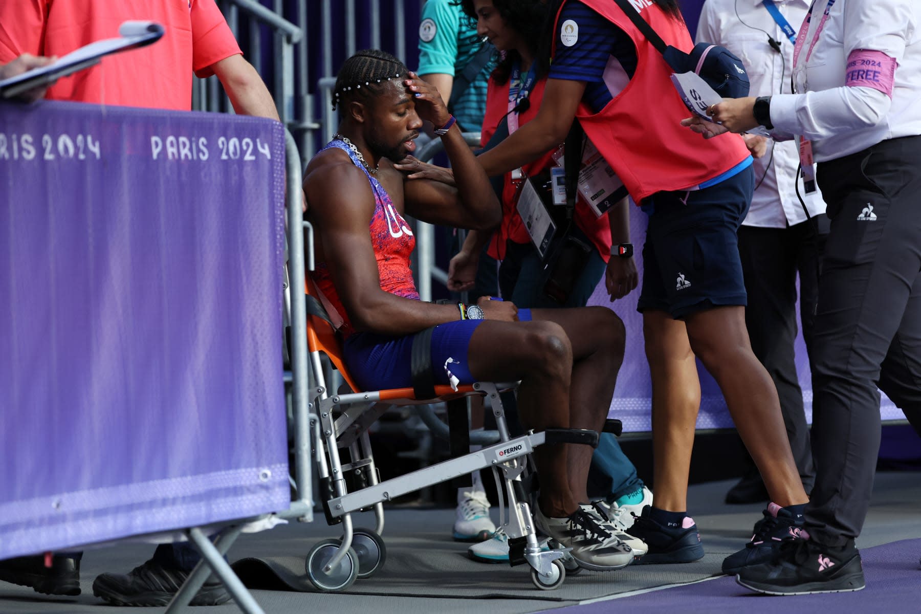PARIS, FRANCE - AUGUST 08: Bronze medalist Noah Lyles of Team United States is taken off from the track with a wheelchair after competing in the Men's 200m Final on day thirteen of the Olympic Games Paris 2024 at Stade de France on August 08, 2024 in Paris, France. (Photo by Hannah Peters/Getty Images)