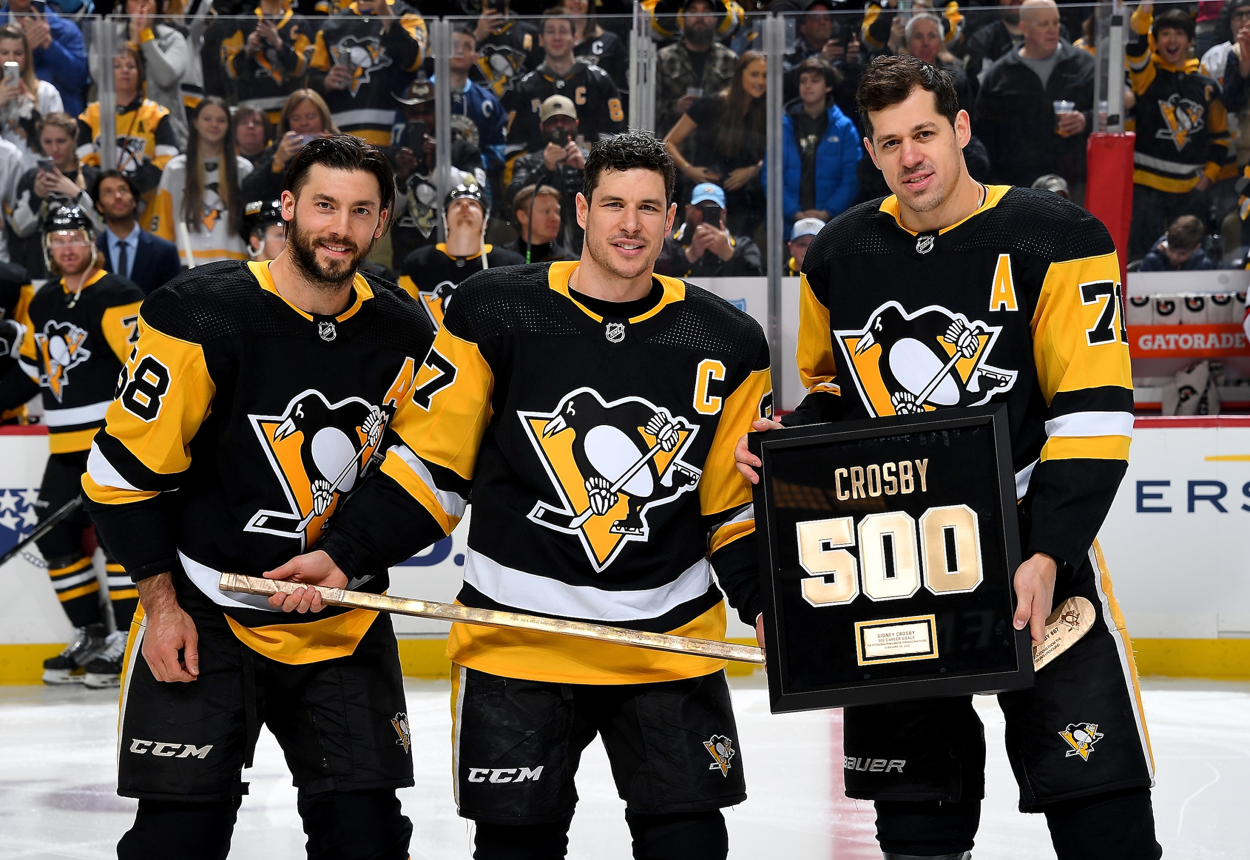 PITTSBURGH, PA - FEBRUARY 20:  Sidney Crosby #87 of the Pittsburgh Penguins poses for a photo with Kris Letang #58 and Evgeni Malkin #71 after being presented with a plaque and stick after scoring 500 NHL goals before the game against the Carolina Hurricanes at PPG PAINTS Arena on February 20, 2022 in Pittsburgh, Pennsylvania. (Photo by Joe Sargent/NHLI via Getty Images)