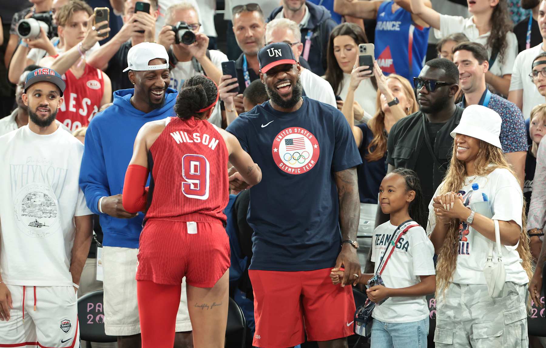 PARIS, FRANCE - AUGUST 11: Derrick White,  Bam Adebayo, LeBron James of USA, his daughter Zhuri James and his wife Savannah James congratulates A'ja Wilson of USA following the victory of Team USA following the Basketball Women's Gold Medal match between Team France and Team USA on day sixteen of the Olympic Games Paris 2024 at Bercy Arena on August 11, 2024 in Paris, France. (Photo by Jean Catuffe/Getty Images)
