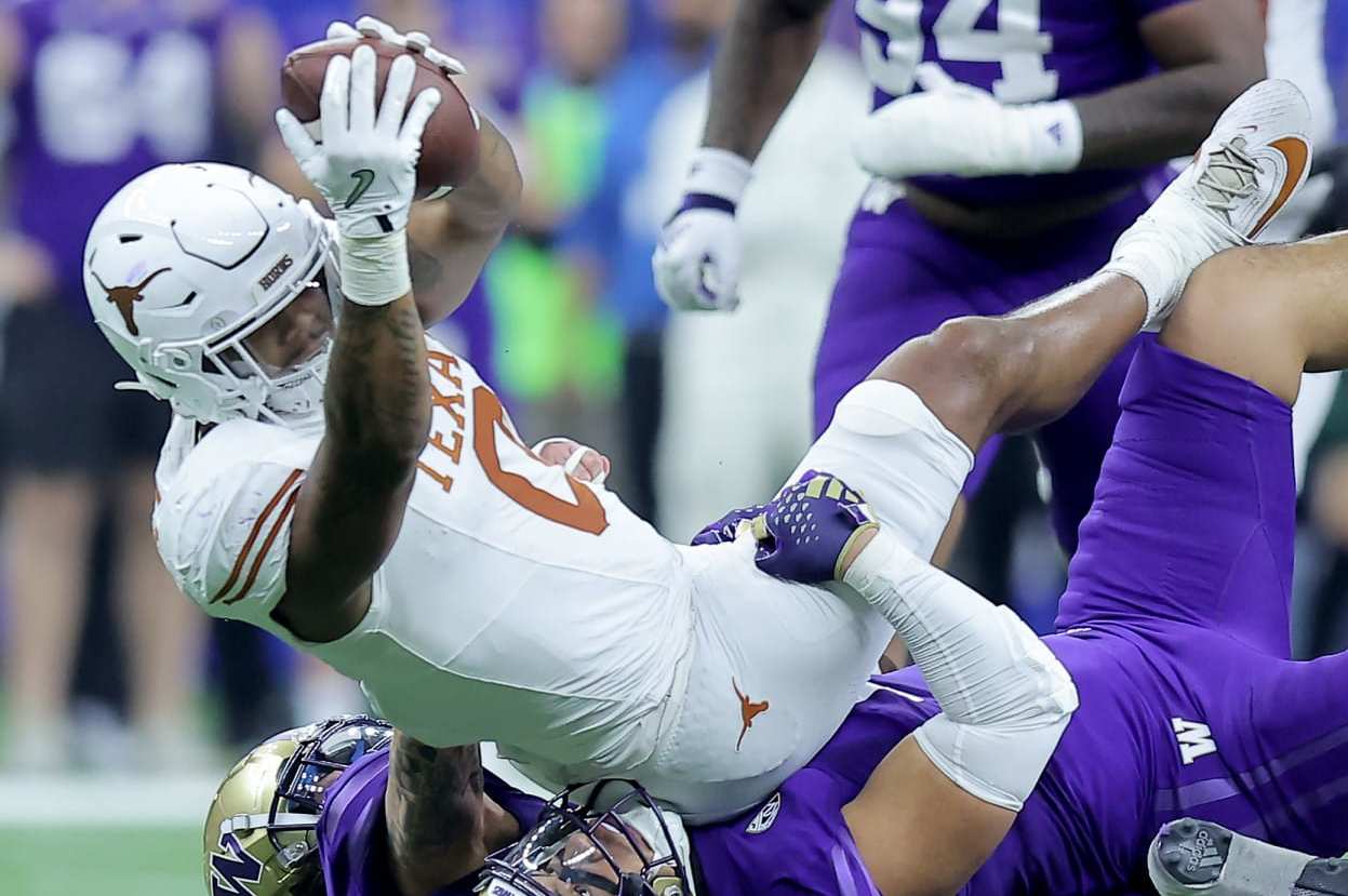 NEW ORLEANS, LOUISIANA - JANUARY 01: Ja'Tavion Sanders #0 of the Texas Longhorns is tackled by Alphonzo Tuputala #11 and Asa Turner #20 of the Washington Huskies after a catch during the second quarter during the CFP Semifinal Allstate Sugar Bowl at Caesars Superdome on January 01, 2024 in New Orleans, Louisiana. (Photo by Jonathan Bachman/Getty Images)