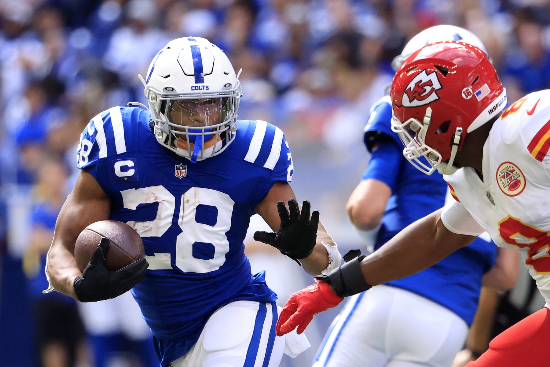 INDIANAPOLIS, INDIANA - SEPTEMBER 25: Jonathan Taylor #28 of the Indianapolis Colts runs with the ball against Carlos Dunlap #8 of the Kansas Metropolis Chiefs for the duration of the 2nd half of at Lucas Oil Stadium on September 25, 2022 in Indianapolis, Indiana. (Photo by Justin Casterline/Getty Photos)