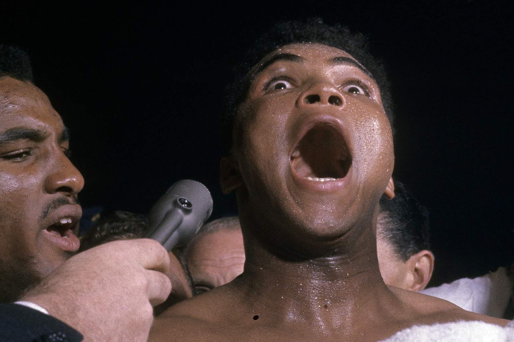 MIAMI, FL - FEBRUARY 25, 1964: Cassius Clay (L) talks into a reporters mike after defeating Sonny Liston, not pictured  in a World Heavyweight Title fight February 25, 1964 at Convention Hall in Miami, Florida.(Photo by Focus On Sport/Getty Images)