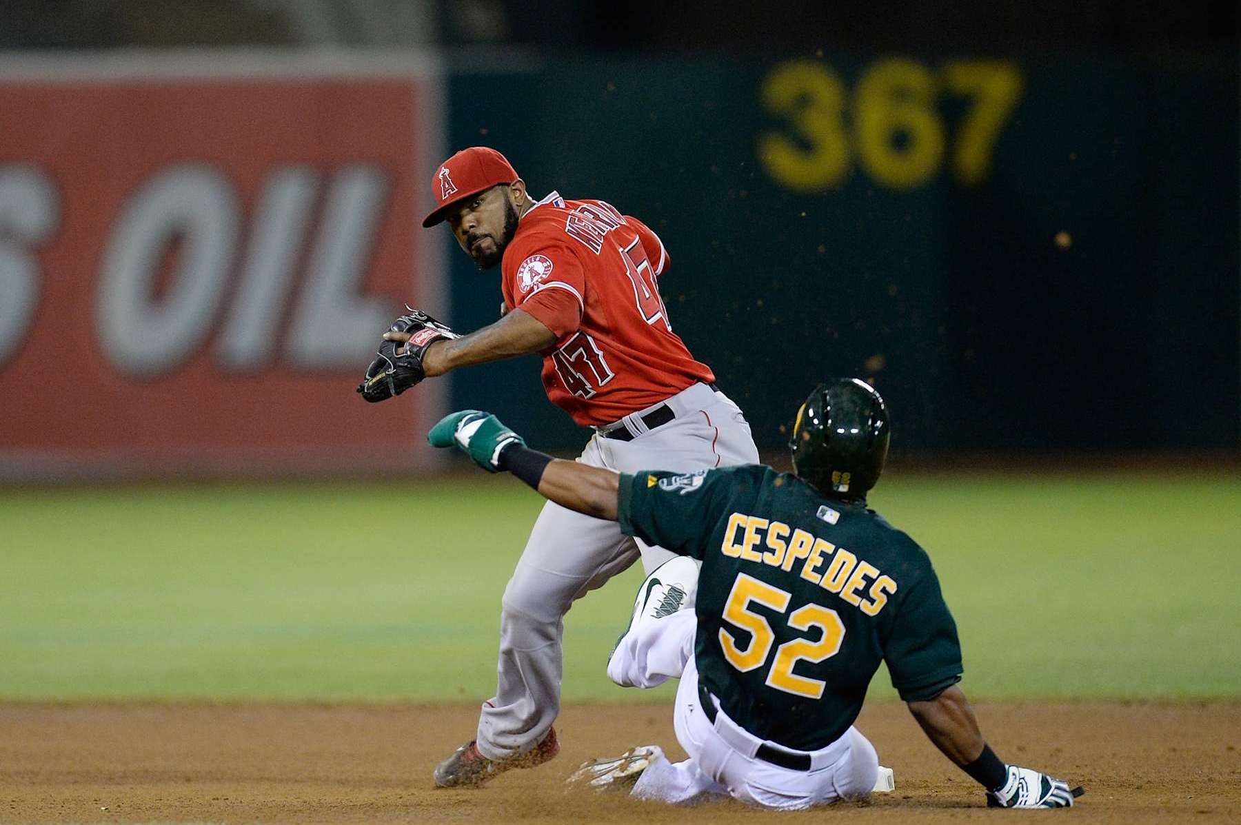 OAKLAND, CA - SEPTEMBER 16: Howie Kendrick #47 of the Los Angeles Angels of Anaheim gets his throw off over the sliding Yoenis Cespedes #52 of the Oakland Athletics but not in time to complete the double-play during the fourth inning at O.co Coliseum on September 16, 2013 in Oakland, California. (Photo by Thearon W. Henderson/Getty Images)