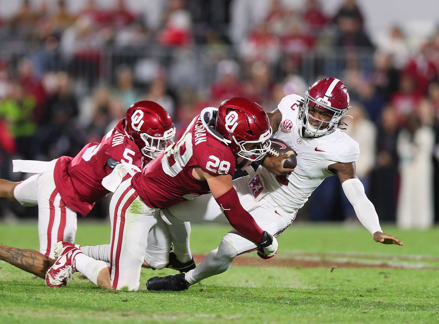 NORMAN, OK - NOVEMBER 23:Oklahoma Sooners LB Danny Stutsman (28) makes a tackle on Alabama Crimson Tide QB Jalen Milroe (04) during a game between the Oklahoma Sooners and the Alabama Crimson Tide at Gaylord Memorial Stadium in Norman, Oklahoma on November 23, 2024. (Photo by David Stacy/Icon Sportswire via Getty Images)