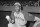 Satchel Paige, pitcher for the Negro League's Kansas City Monarchs, stands at the top of the dugout with baseball in hand. 1942.