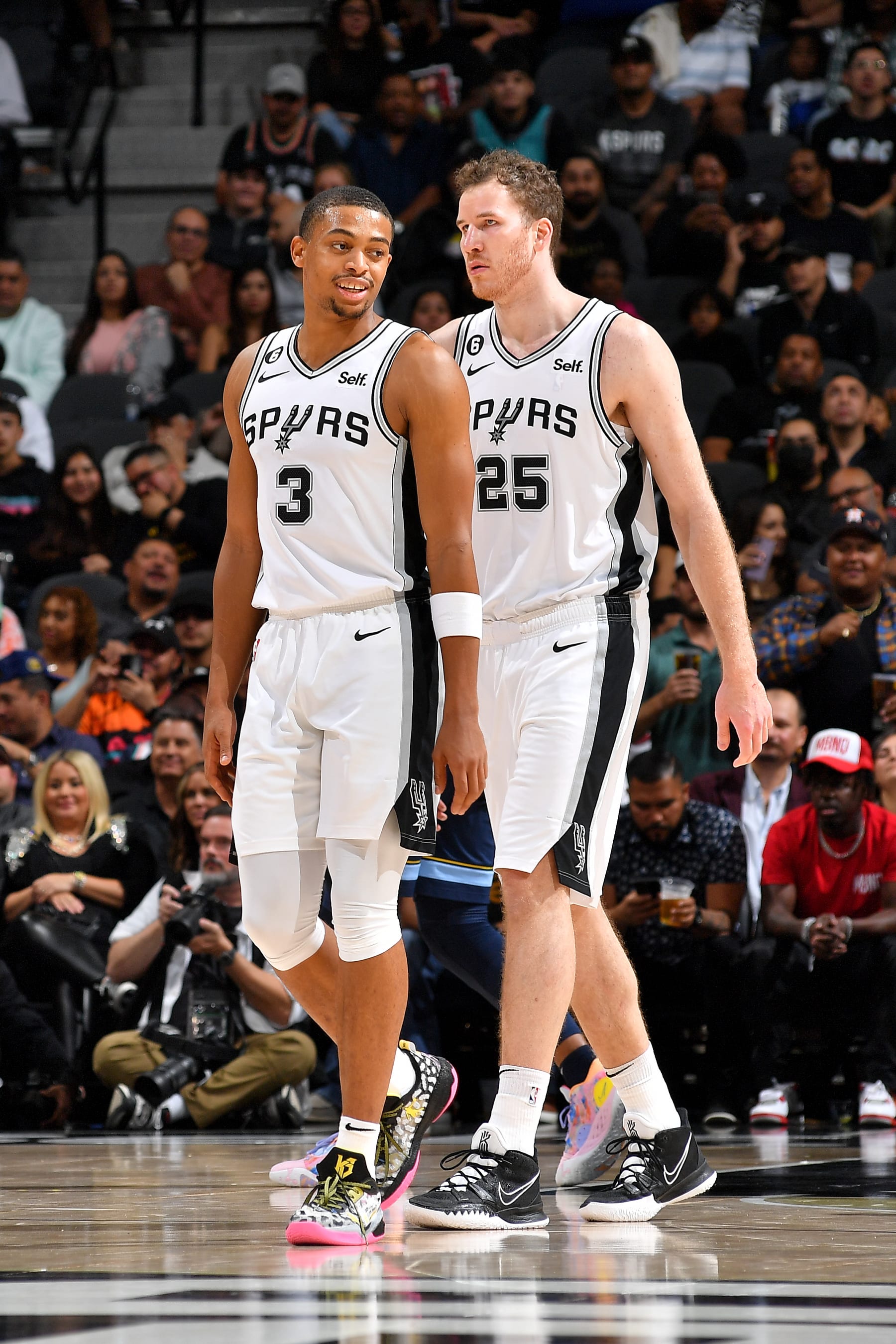 SAN ANTONIO, TX - NOVEMBER 9: Keldon Johnson #3 and Jakob Poeltl #25 of the San Antonio Spurs talk on the court during the game against the Memphis Grizzlies on November 9, 2022 at the AT&T Center in San Antonio, Texas. NOTE TO USER: User expressly acknowledges and agrees that, by downloading and or using this photograph, user is consenting to the terms and conditions of the Getty Images License Agreement. Mandatory Copyright Notice: Copyright 2022 NBAE (Photos by Michael Gonzales/NBAE via Getty Images)