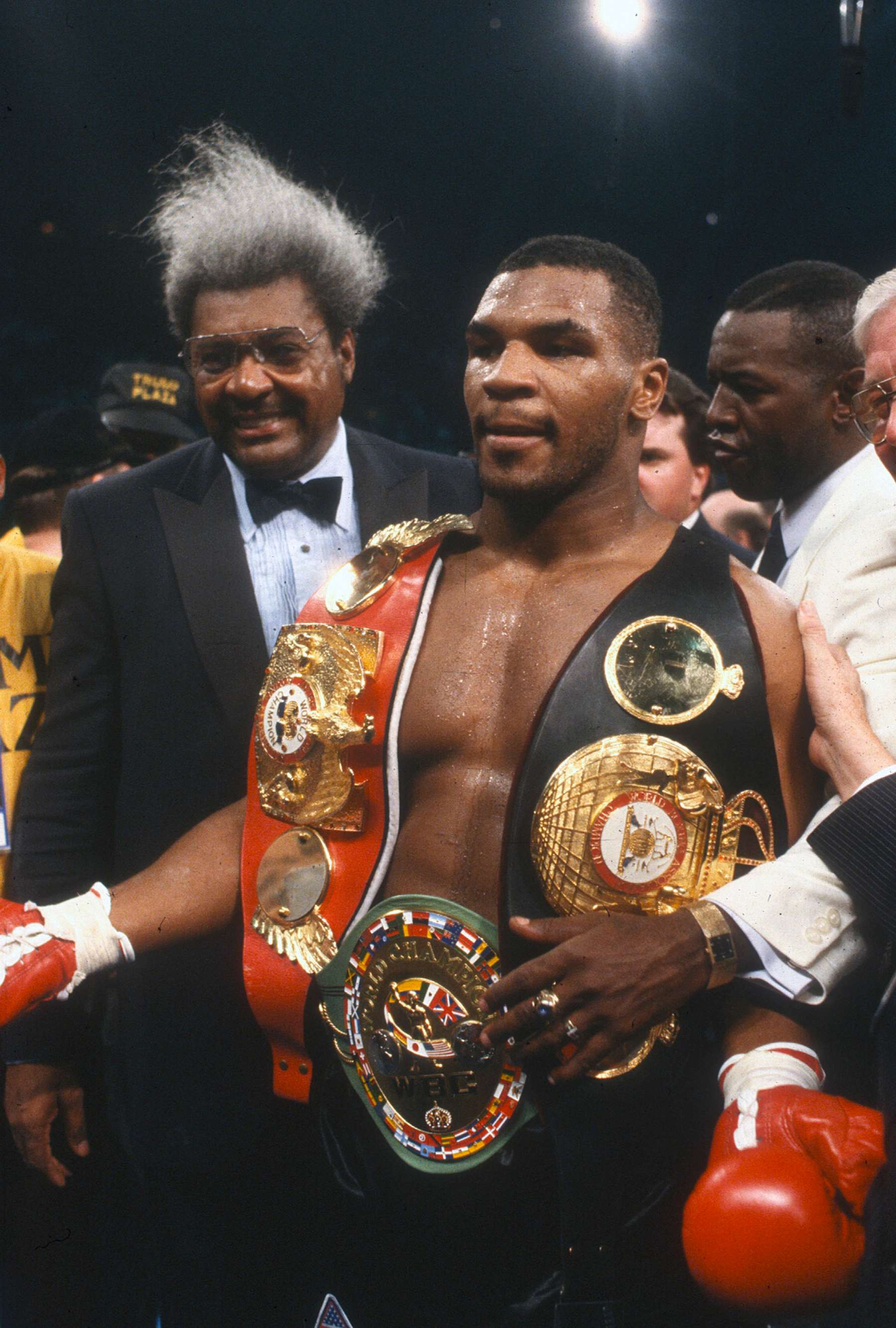 ATLANTIC CITY, NJ - JANUARY 22: Mike Tyson celebrates wearing all three belts after he defeated Larry Holmes for the WBA, WBC and IBF heavyweight tittles on January 22, 1988 at the Convention Hall in Atlantic City, New Jersey. Tyson won the fight with a TKO in the 4th round. (Photo by Focus on Sport/Getty Images)
