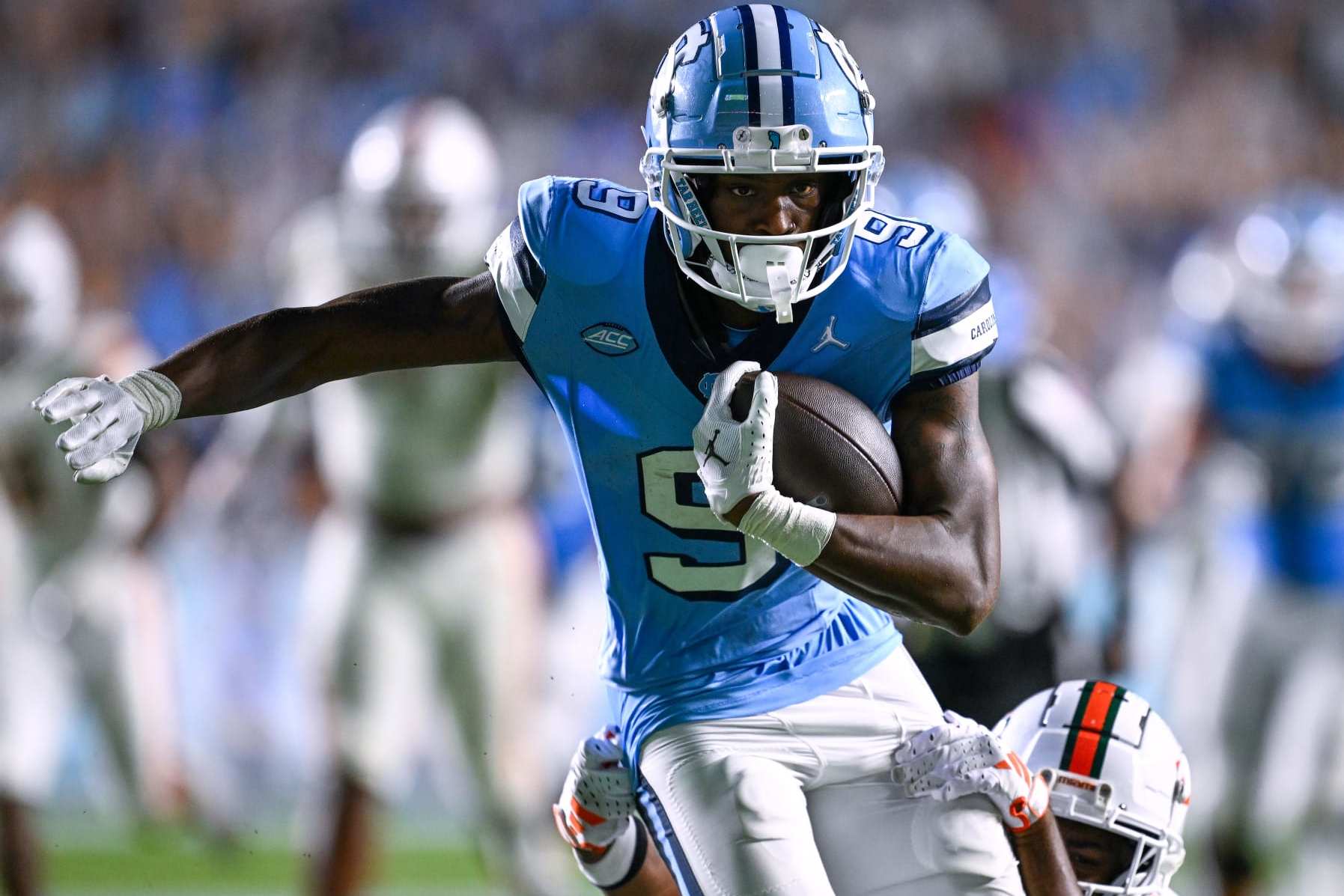 CHAPEL HILL, NORTH CAROLINA - OCTOBER 14: Devontez Walker #9 of the North Carolina Tar Heels breaks away from  Kamren Kinchens #5 of the Miami Hurricanes for a touchdown during the second half of their game at Kenan Memorial Stadium on October 14, 2023 in Chapel Hill, North Carolina. The Tar Heels won 41-31. (Photo by Grant Halverson/Getty Images)