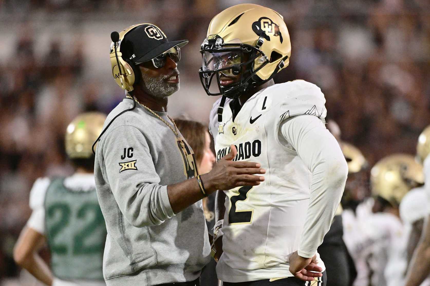 ORLANDO, FLORIDA - SEPTEMBER 28: Head coach Deion Sanders of the Colorado Buffaloes talks with Shedeur Sanders #2 during the second half of a game against the UCF Knights at FBC Mortgage Stadium on September 28, 2024 in Orlando, Florida. (Photo by Julio Aguilar/Getty Images)