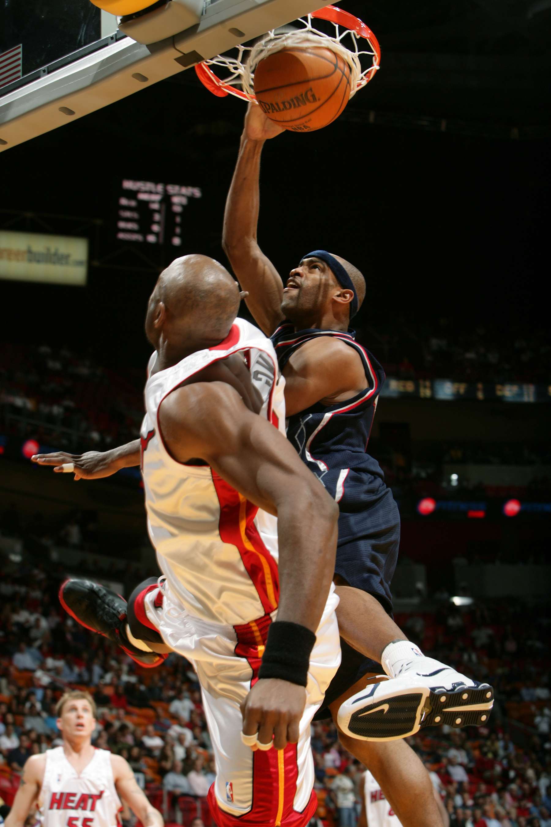 MIAMI - NOVEMBER 7:  Vince Carter #15 of the New Jersey Nets dunks over Alonzo Mourning #33 of the Miami Heat November 7, 2005 at American Airlines Arena in Miami, Florida. NOTE TO USER: User expressly acknowledges and agrees that, by downloading and/or using this Photograph, user is consenting to the terms and conditions of the Getty Images License Agreement. Mandatory copyright notice: Copyright NBAE 2005  (Photo by Victor Baldizon/NBAE via Getty Images)