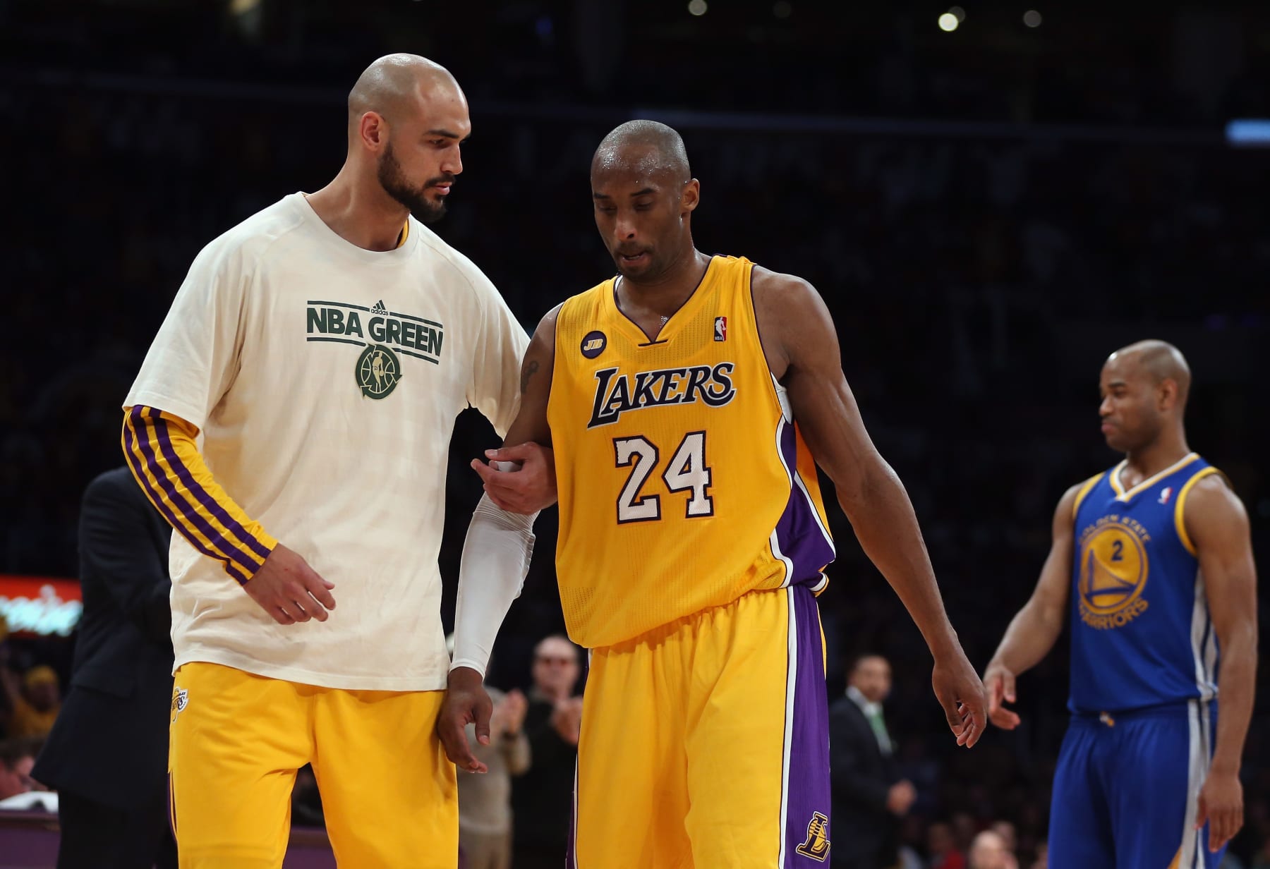 LOS ANGELES, CA - APRIL 12:  Kobe Bryant #24 of the Los Angeles Lakers is helped off the court by teammate Robert Sacre after injuring himself against the Golden State Warriors in the second half at Staples Center on April 12, 2013 in Los Angeles, California. The Lakers defeated the Warriors 118-116. NOTE TO USER: User expressly acknowledges and agrees that, by downloading and or using this photograph, User is consenting to the terms and conditions of the Getty Images License Agreement.  (Photo by Jeff Gross/Getty Images)