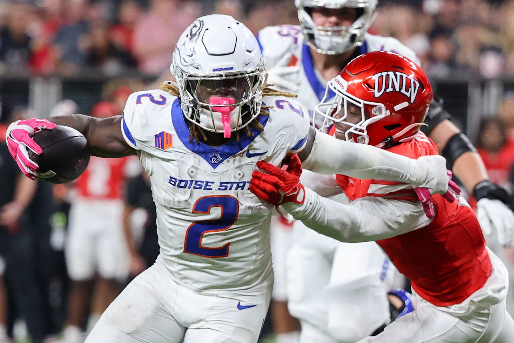 LAS VEGAS, NEVADA - OCTOBER 25: Ashton Jeanty #2 of the Boise State Broncos stiff arms Jett Elad #9 of the UNLV Rebels during the fourth quarter of a game at Allegiant Stadium on October 25, 2024 in Las Vegas, Nevada. (Photo by Ian Maule/Getty Images)