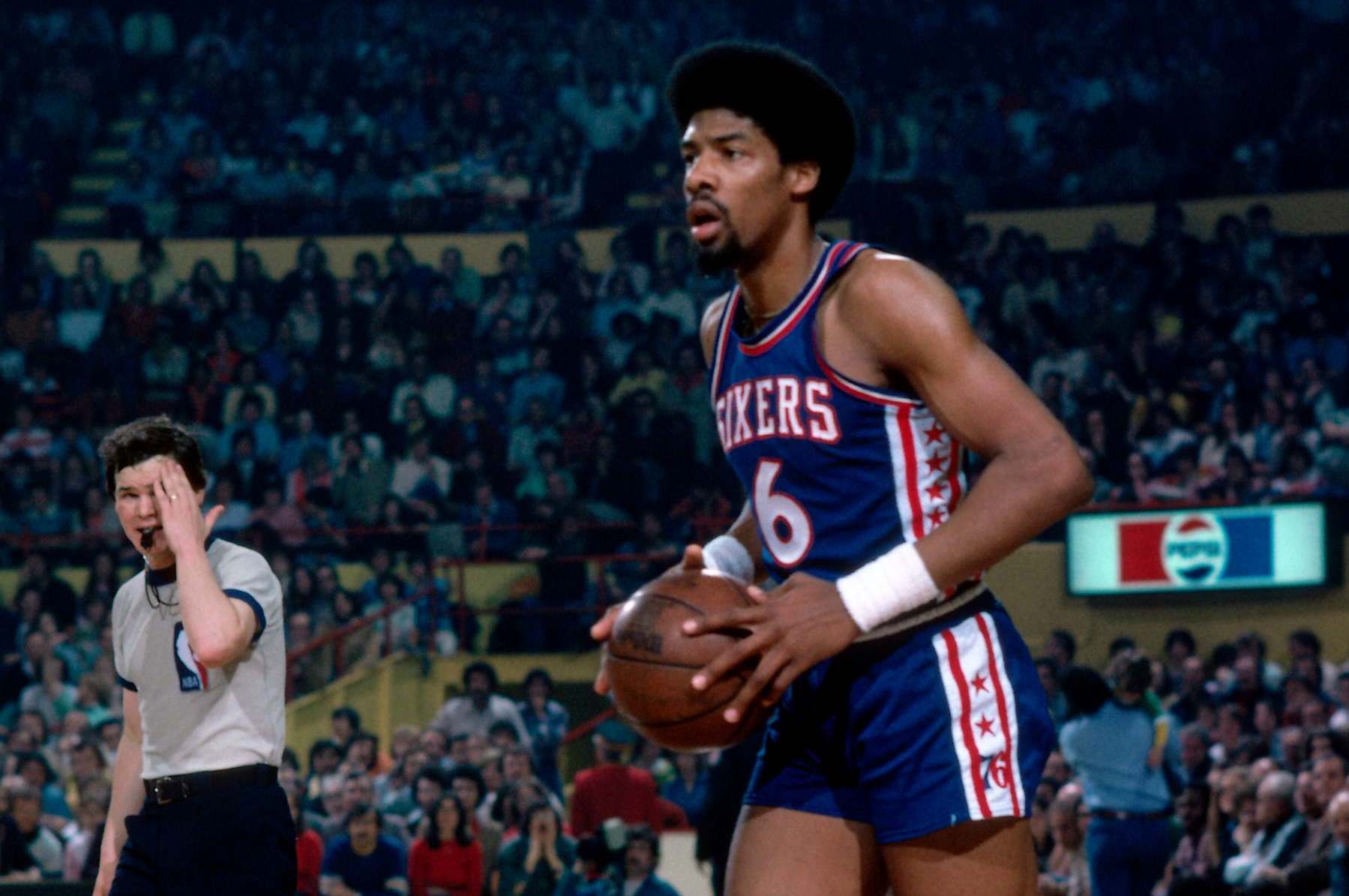 BOSTON, MA - 1977: Julius Erving #6 of the Philadelphia 76ers looks to pass the ball during a game played circa 1977 at the Boston Garden in Boston, Massachusetts. NOTE TO USER: User expressly acknowledges and agrees that, by downloading and or using this photograph, User is consenting to the terms and conditions of the Getty Images License Agreement. Mandatory Copyright Notice: Copyright 1977 NBAE (Photo by Dick Raphael/NBAE via Getty Images)