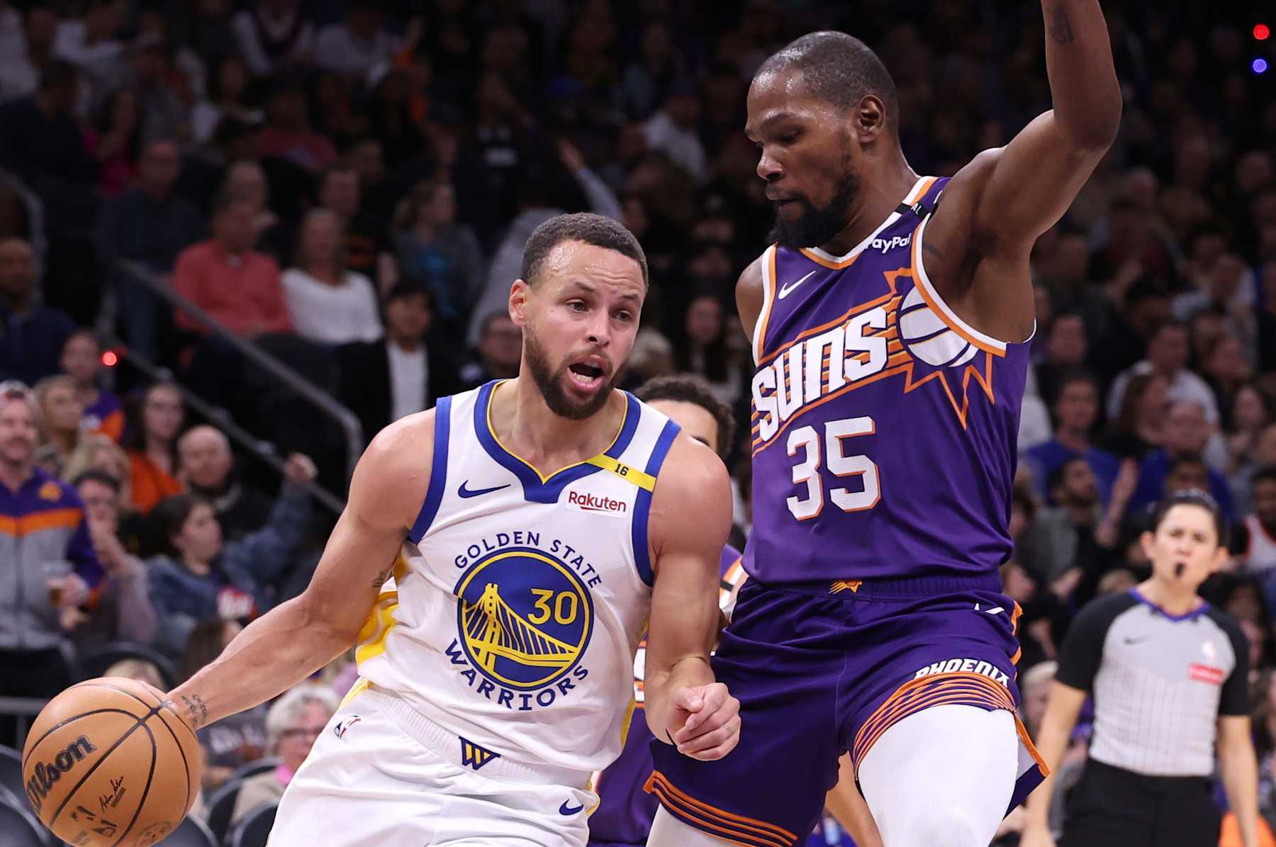 PHOENIX, ARIZONA - NOVEMBER 30: Stephen Curry #30 of the Golden State Warriors drives on Kevin Durant #35 of the Phoenix Suns during the game at Footprint Center on November 30, 2024 in Phoenix, Arizona. The Suns defeated the Warriors 113-105. NOTE TO USER: User expressly acknowledges and agrees that, by downloading and or using this photograph, User is consenting to the terms and conditions of the Getty Images License Agreement.  (Photo by Chris Coduto/Getty Images)