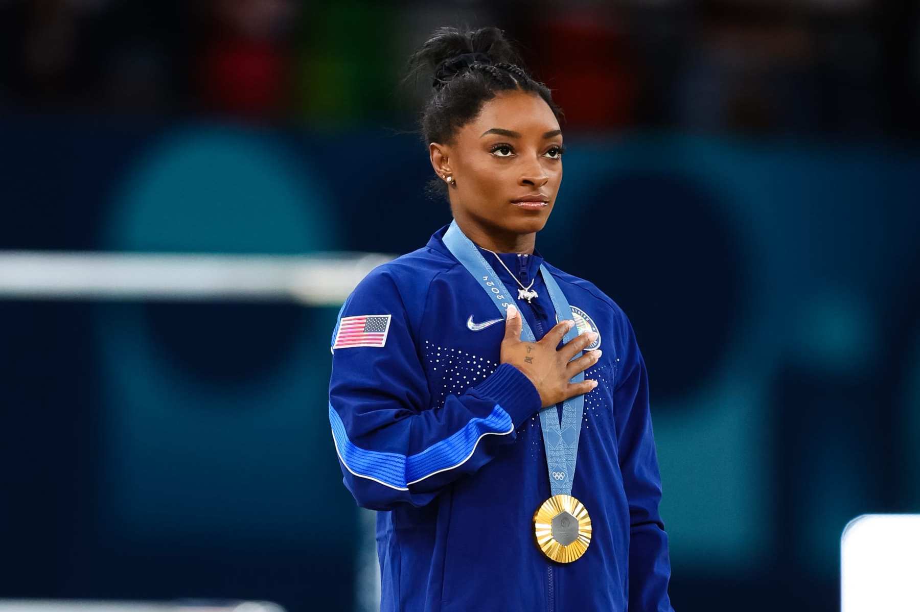 PARIS, FRANCE - AUGUST 01: Simone Biles of USA during the USA National Anthem after winning Gold at the Artistic Gymnastics WomenÕs All-Round Final at the Paris 2024 Olympic Games at the Bercy Arena on August 01, 2024 in Paris, France. (Photo by Pete Dovgan/Speed Media/Icon Sportswire via Getty Images)