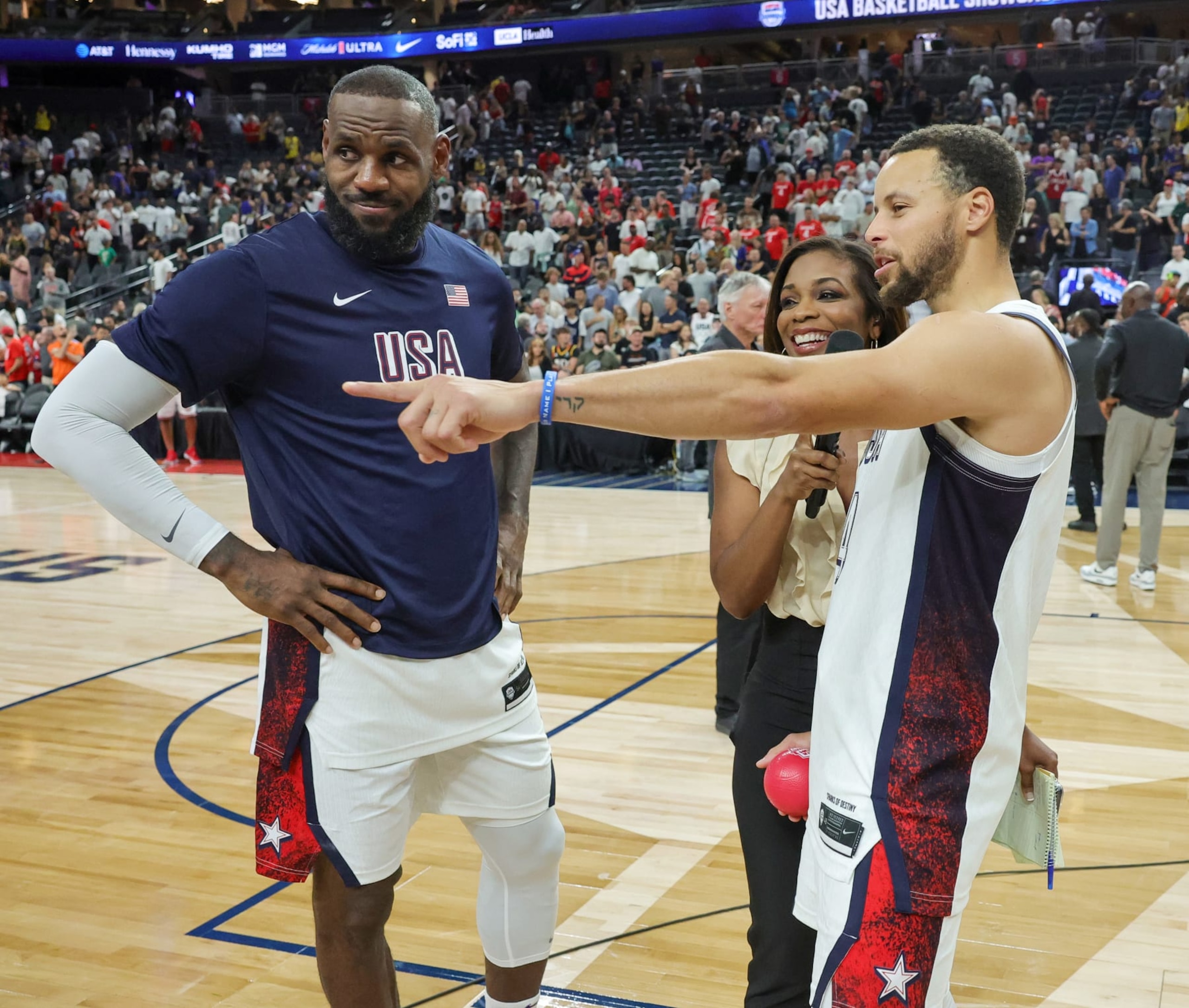 LAS VEGAS, NEVADA - JULY 10: LeBron James (L) #6 and Stephen Curry #4 of the United States are interviewed on the court by Kristina Pink of Fox Sports after the team's 86-72 victory over Canada in their exhibition game ahead of the Paris Olympic Games at T-Mobile Arena on July 10, 2024 in Las Vegas, Nevada. (Photo by Ethan Miller/Getty Images)