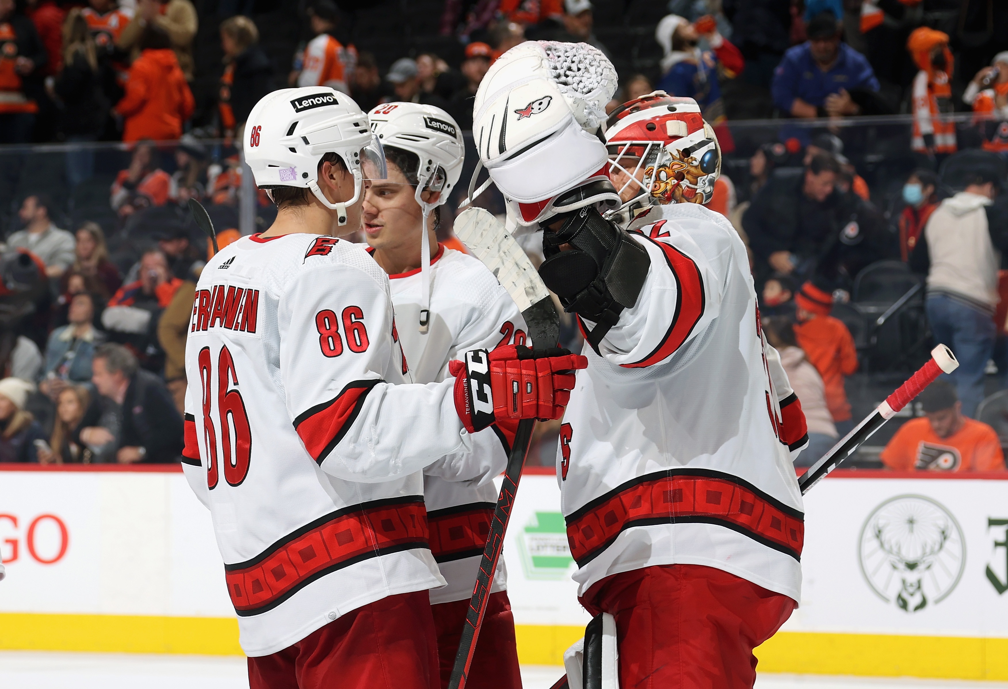 PHILADELPHIA, PA - NOVEMBER 26: Teuvo Teravainen #86, Sebastian Aho #20, and Antti Raanta #32 of the Carolina Hurricanes celebrate after defeating the Philadelphia Flyers 6-3 at the Wells Fargo Center on November 26, 2021 in Philadelphia, Pennsylvania. (Photo by Len Redkoles/NHLI via Getty Images)
