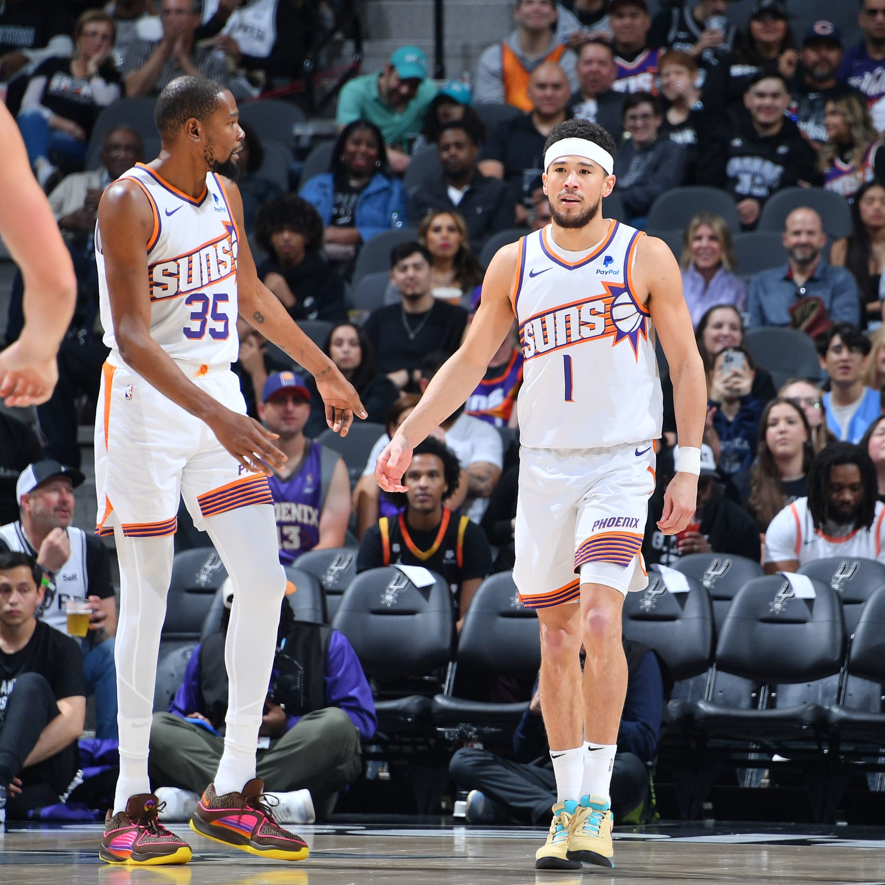 SAN ANTONIO, TX - MARCH 23: Kevin Durant #35 and Devin Booker #1 of the Phoenix Suns look on during the game against the San Antonio Spurs on March 23, 2024 at the Frost Bank Center in San Antonio, Texas. NOTE TO USER: User expressly acknowledges and agrees that, by downloading and or using this photograph, user is consenting to the terms and conditions of the Getty Images License Agreement. Mandatory Copyright Notice: Copyright 2024 NBAE (Photos by Michael Gonzales/NBAE via Getty Images)
