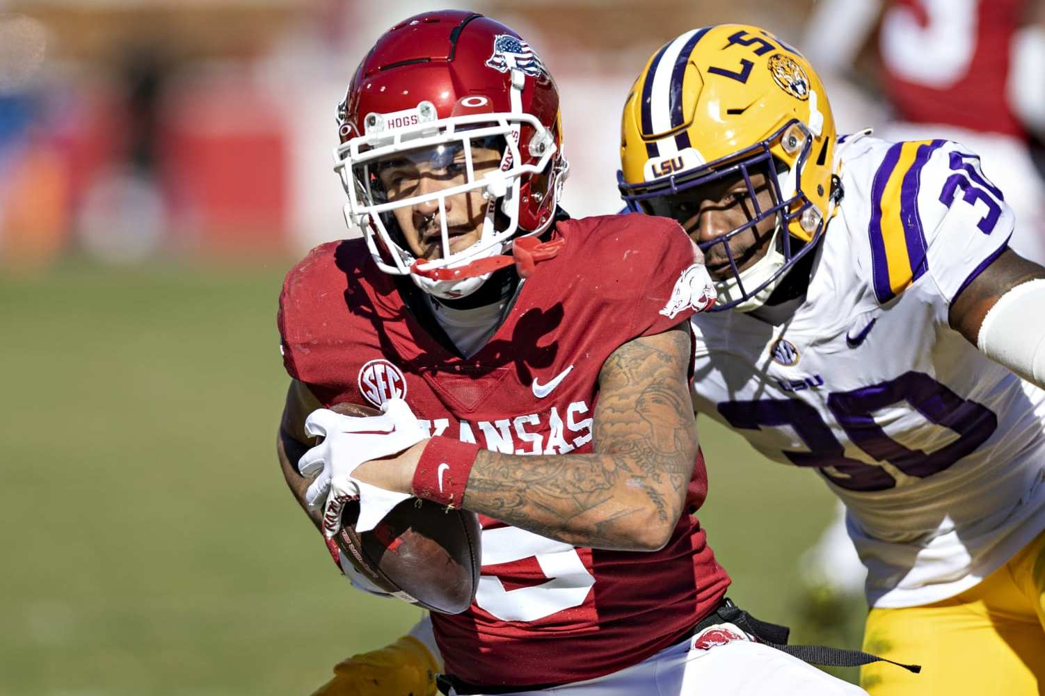 FAYETTEVILLE, ARKANSAS - NOVEMBER 12: Jadon Haselwood #9 of the Arkansas Razorbacks catches a pass and is tackled by Greg Penn III #30 of the LSU Tigers at Donald W. Reynolds Razorback Stadium on November 12, 2022 in Fayetteville, Arkansas. The Tigers defeated the Razorbacks 13-10. (Photo by Wesley Hitt/Getty Images)