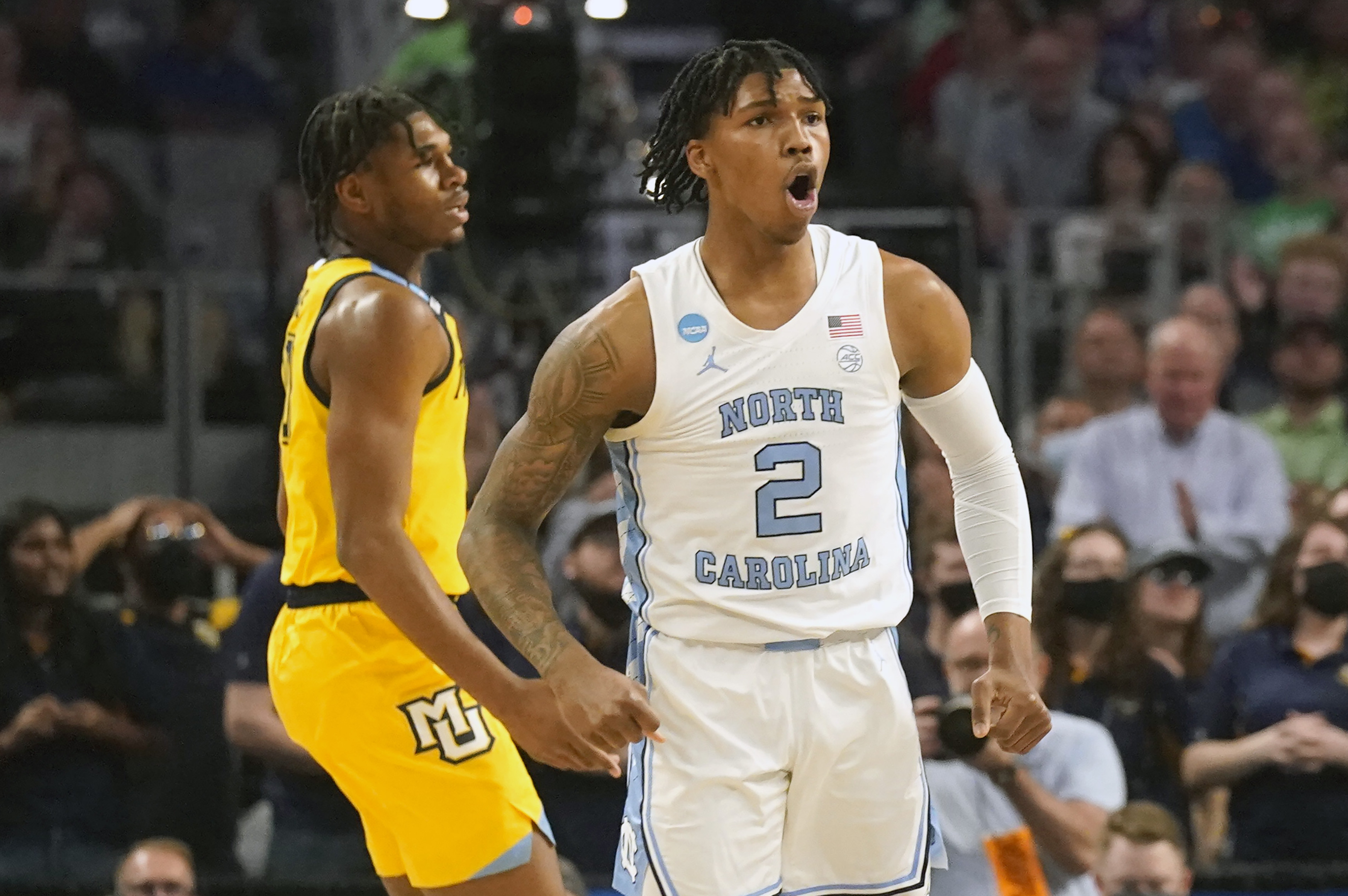 North Carolina guard Caleb Love (2) reacts to scoring, in front of Marquette forward Justin Lewis during the first half of a college basketball game in the first round of the NCAA men's tournament in Fort Worth, Texas, Thursday, March 17, 2022. (AP Photo/LM Otero)