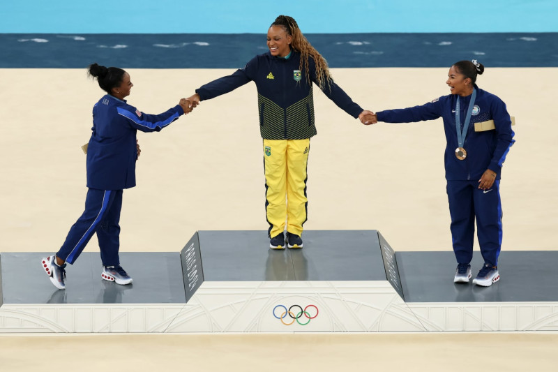 PARIS, FRANCE - AUGUST 05: Gold medalist Rebeca Andrade (C) of Team Brazil, silver medalist Simone Biles (L) of Team United States and bronze medalist Jordan Chiles (R) of Team United States celebrate on the podium at the Artistic Gymnastics Women's Floor Exercise Medal Ceremony on day ten of the Olympic Games Paris 2024 at Bercy Arena on August 05, 2024 in Paris, France. (Photo by Elsa/Getty Images)