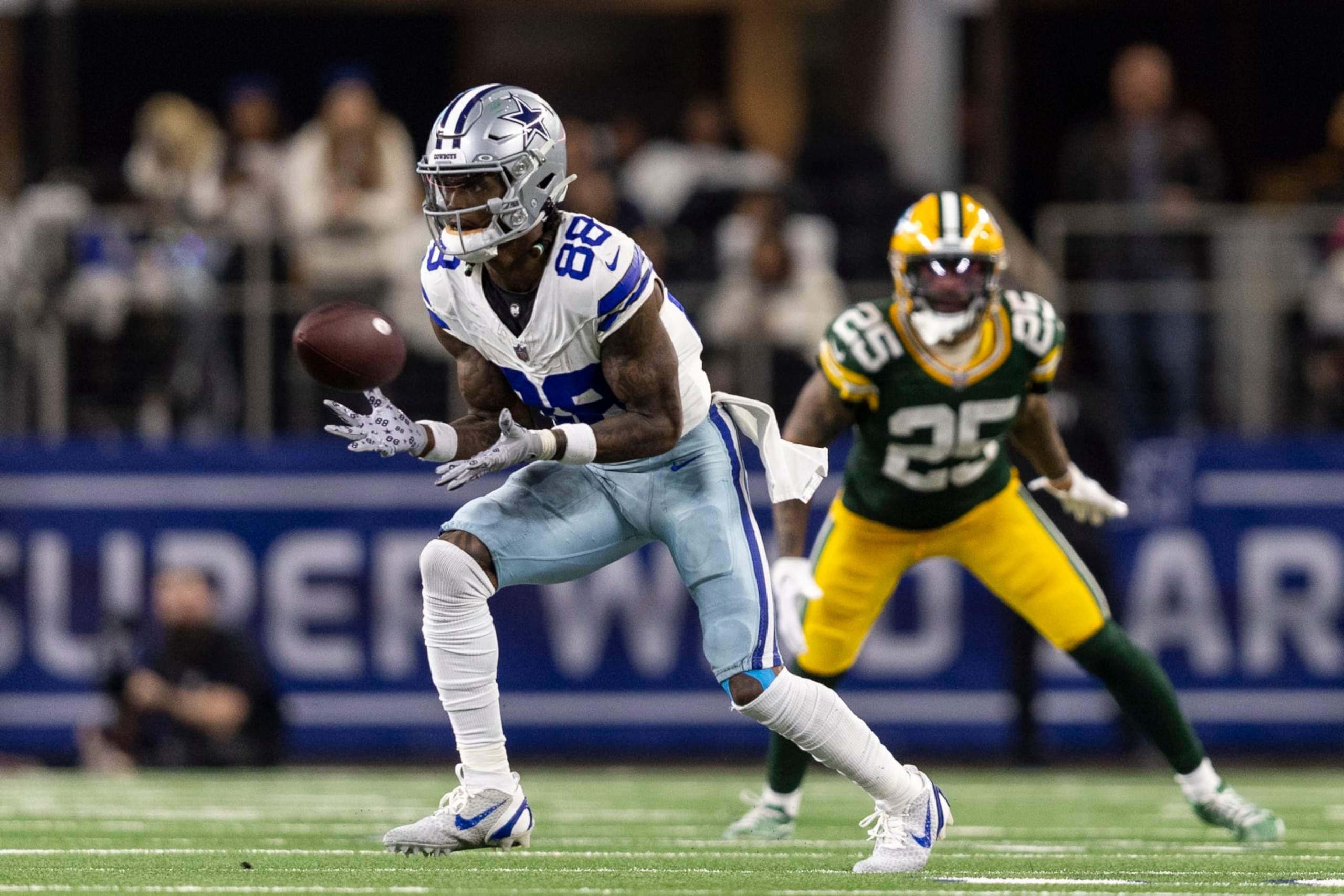 ARLINGTON, TEXAS - JANUARY 14: CeeDee Lamb #88 of the Dallas Cowboys completes a pass against Keisean Nixon #25 of the Green Bay Packers during an NFL wild-card playoff football game between the Dallas Cowboys and the Green Bay Packers at AT&T Stadium on January 14, 2024 in Arlington, Texas. (Photo by Michael Owens/Getty Images)