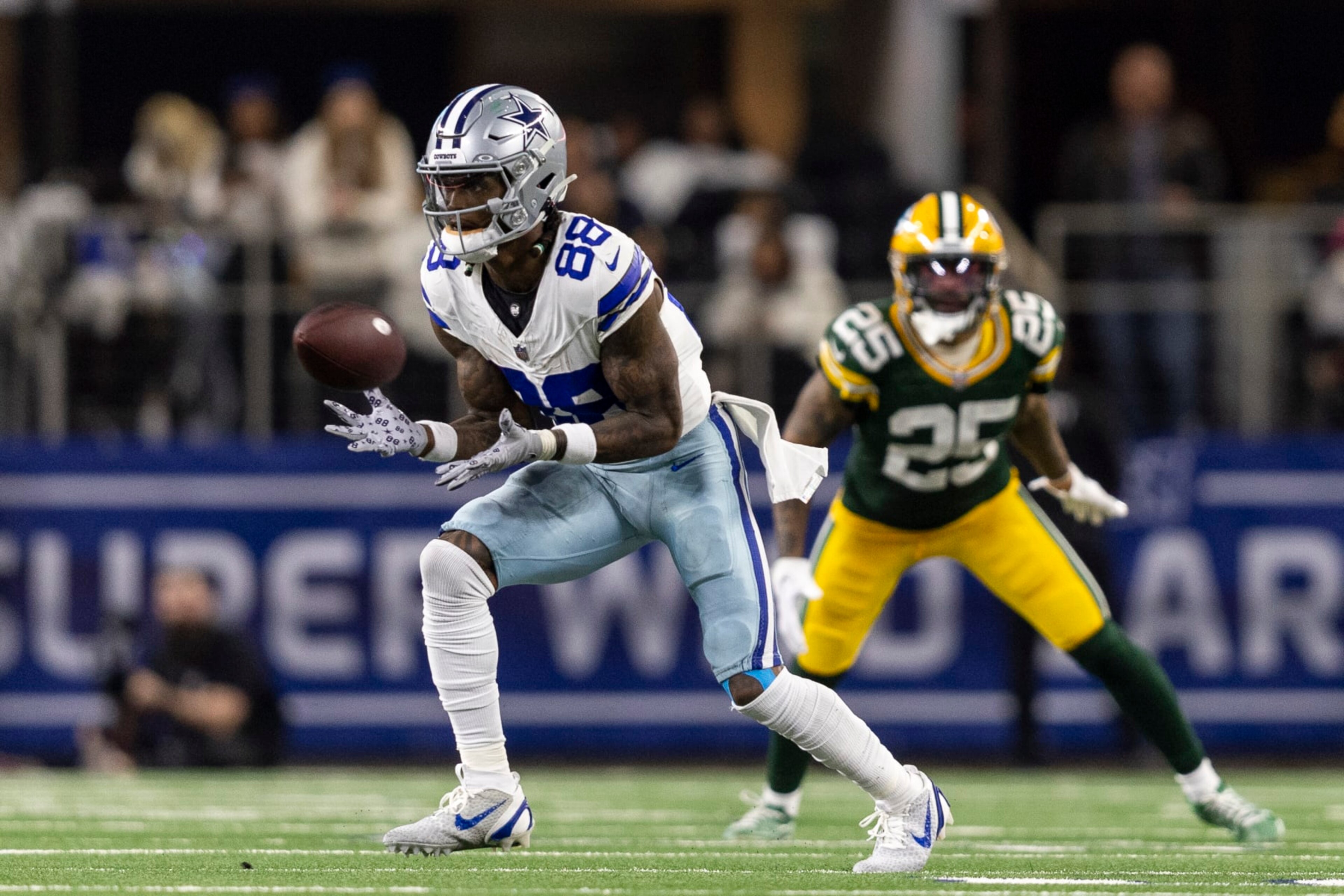 ARLINGTON, TEXAS - JANUARY 14: CeeDee Lamb #88 of the Dallas Cowboys completes a pass against Keisean Nixon #25 of the Green Bay Packers during an NFL wild-card playoff football game between the Dallas Cowboys and the Green Bay Packers at AT&T Stadium on January 14, 2024 in Arlington, Texas. (Photo by Michael Owens/Getty Images)