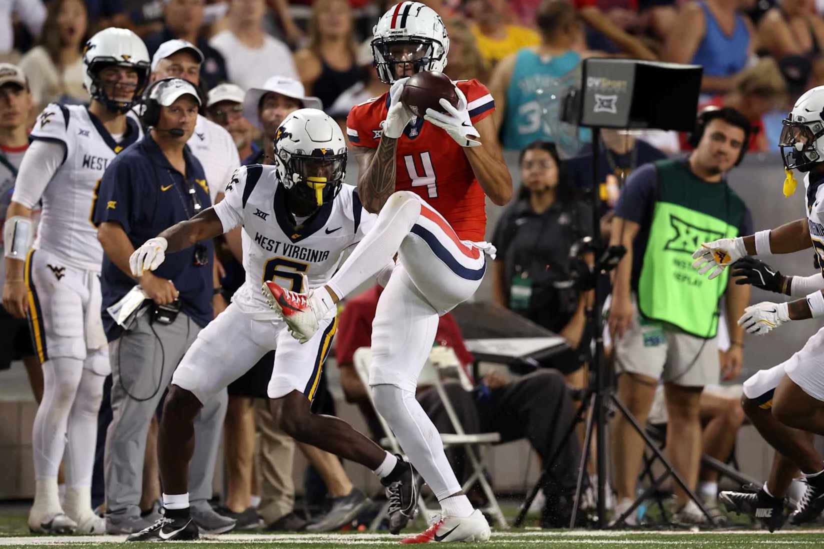 TUCSON, ARIZONA - OCTOBER 26: Wide receiver Tetairoa McMillan #4 of the Arizona Wildcats catches a pass over cornerback Jacolby Spells #6 of the West Virginia Mountaineers during the game at Arizona Stadium on October 26, 2024 in Tucson, Arizona. The Mountaineers defeated the Wildcats 31-26. (Photo by Chris Coduto/Getty Images)