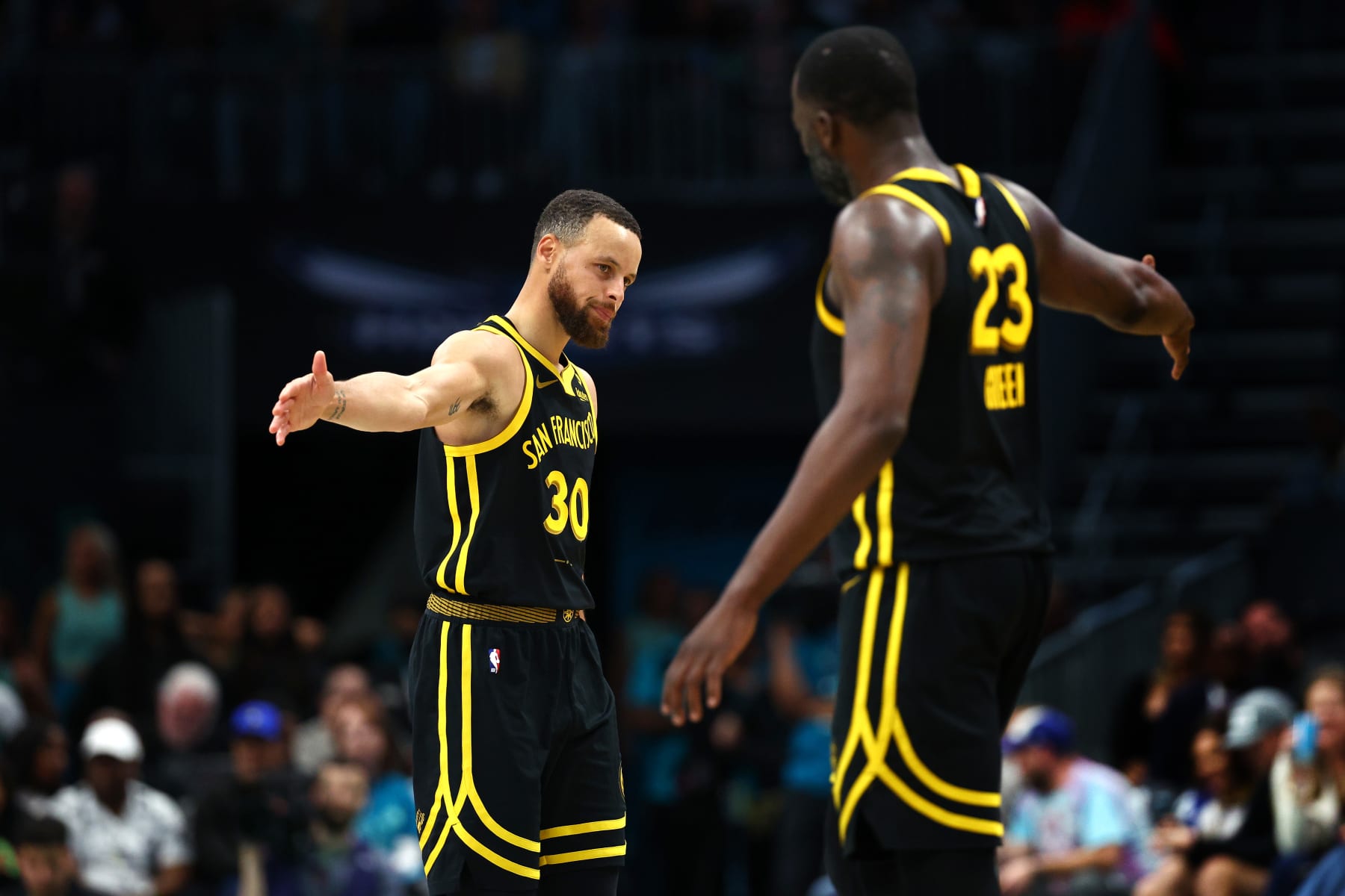 CHARLOTTE, NORTH CAROLINA - MARCH 29: Stephen Curry #30 and Draymond Green #23 of the Golden State Warriors react during the second half of the game against the Charlotte Hornets at Spectrum Center on March 29, 2024 in Charlotte, North Carolina. NOTE TO USER: User expressly acknowledges and agrees that, by downloading and or using this photograph, User is consenting to the terms and conditions of the Getty Images License Agreement. (Photo by Jared C. Tilton/Getty Images)