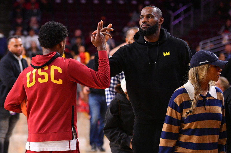 LOS ANGELES, CA - JANUARY 06: USC Trojans guard Bronny James (6) gives his dad LeBron James a high five before the college basketball game between the Stanford Cardinal and the USC Trojans on January 6, 2024 at Galen Center in Los Angeles, CA. (Photo by Brian Rothmuller/Icon Sportswire via Getty Images)