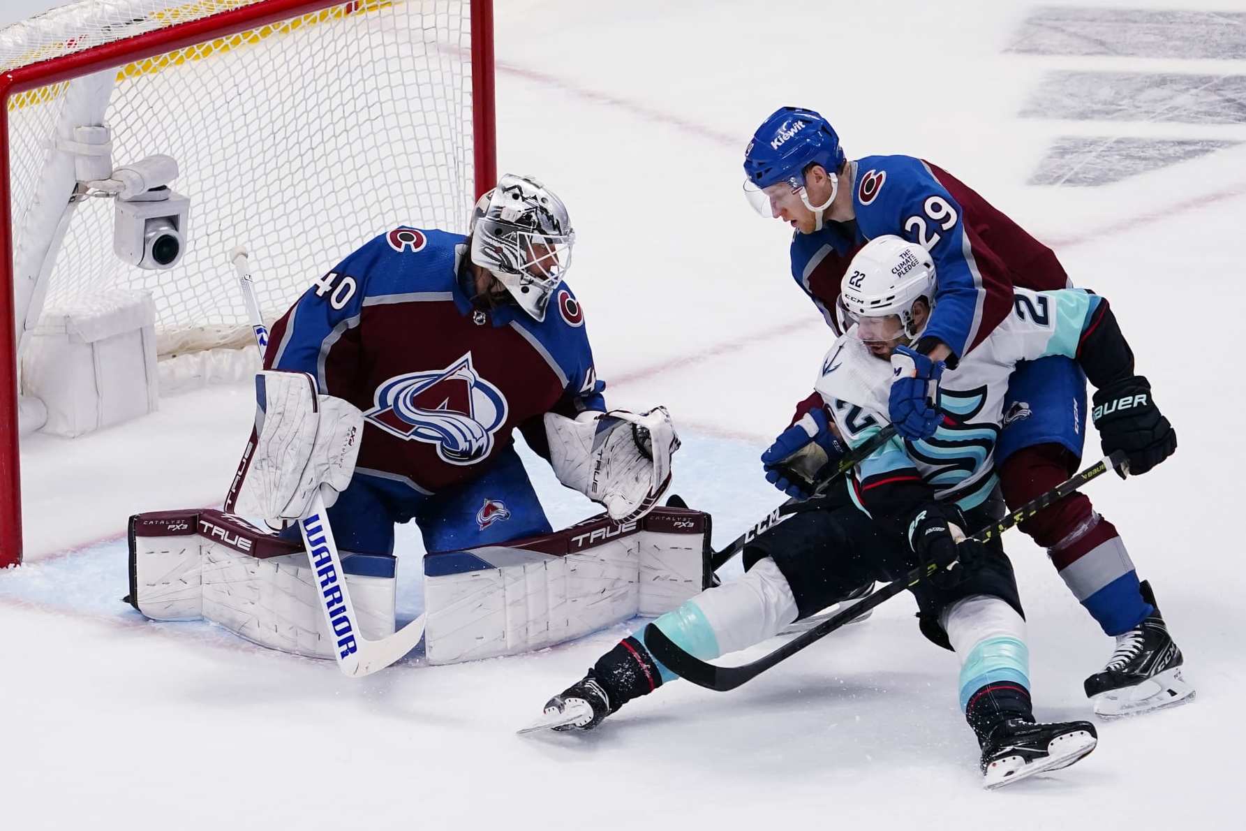 Colorado Avalanche center Nathan McKinnon (29) tangles with Seattle Kraken right wing Oliver Bjorkstrand (22) in front of Avalanche goaltender Alexandar George (40) during the first period in Game 1 of a first-round NHL hockey playoff series Tuesday, April 18, 2023, in Denver (AP Photo/Jack Dempsey)