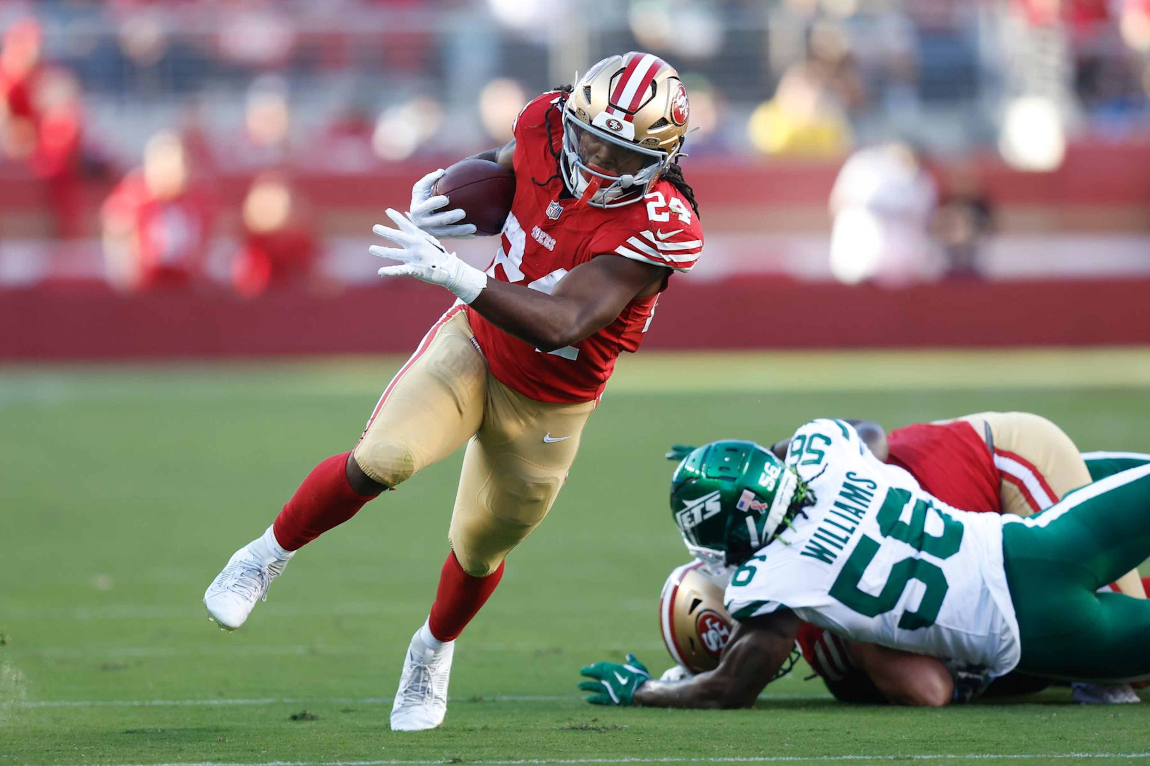 SANTA CLARA, CALIFORNIA - SEPTEMBER 09: Jordan Mason #24 of the San Francisco 49ers runs with the ball against Quincy Williams #56 of the New York Jets during the first half at Levi's Stadium on September 09, 2024 in Santa Clara, California. (Photo by Lachlan Cunningham/Getty Images)