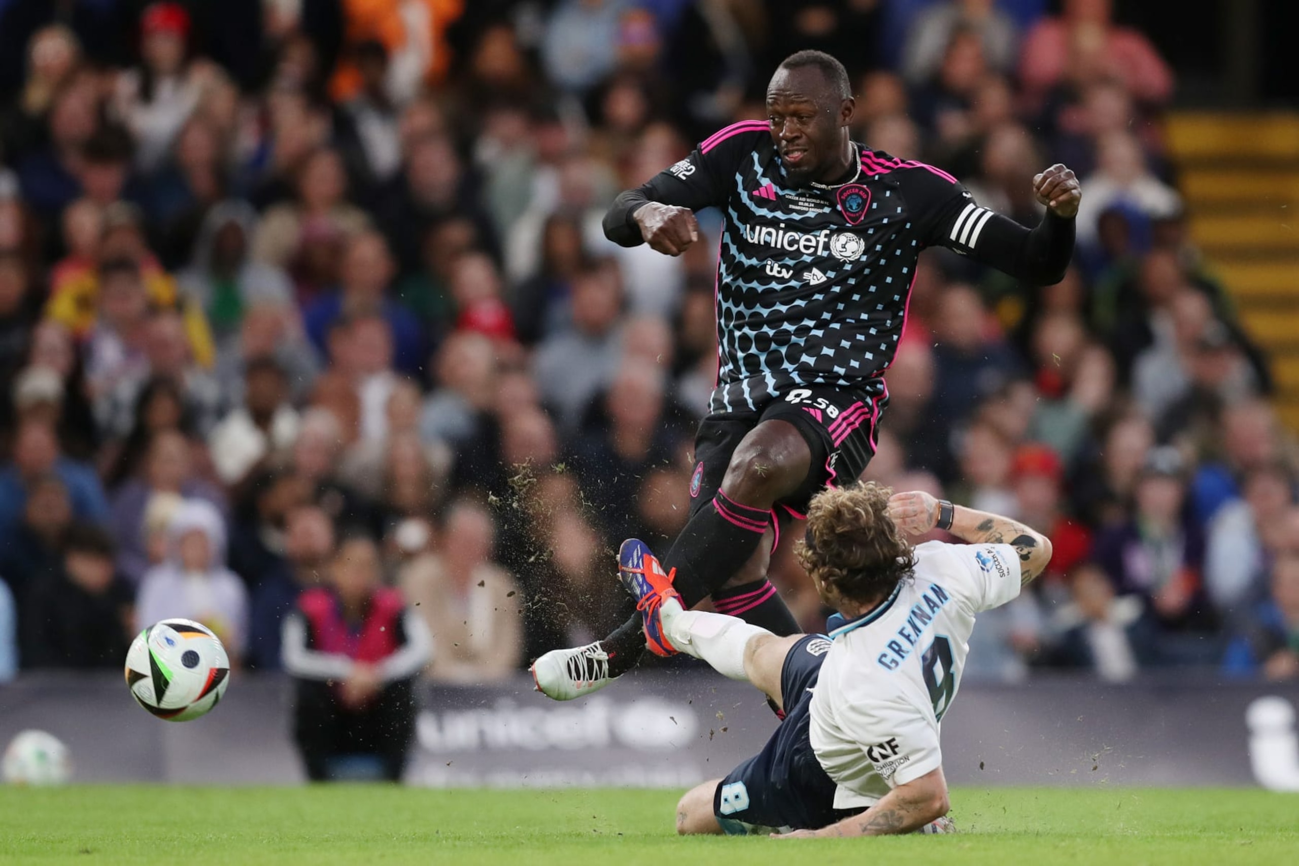 LONDON, ENGLAND - JUNE 09: Usain Bolt of World XI is challenged by Tom Grennan of England during Soccer Aid for UNICEF 2024 at Stamford Bridge on June 09, 2024 in London, England. (Photo by Henry Browne/Getty Images)