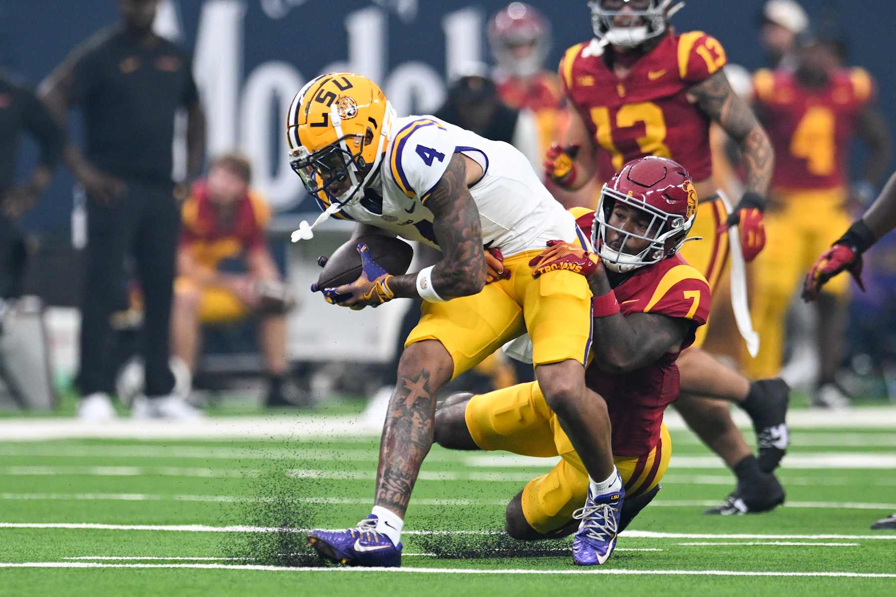 LAS VEGAS, NEVADA - SEPTEMBER 01: CJ Daniels #4 of the LSU Tigers is tackled by Kamari Ramsey #7 of the USC Trojans in the first quarter of the Vegas Kickoff Classic at Allegiant Stadium on September 01, 2024 in Las Vegas, Nevada. The Trojans defeated the Tigers 27-20. (Photo by Candice Ward/Getty Images)