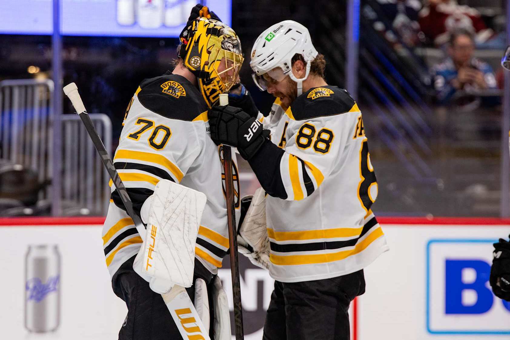 DENVER, COLORADO - OCTOBER 16: Joonas Korpisalo #70 and David Pastrnak #88 of the Boston Bruins hug after defeating the Colorado Avalanche 5-3 at Ball Arena on October 16, 2024 in Denver, Colorado. (Photo by Ashley Potts/NHLI via Getty Images)