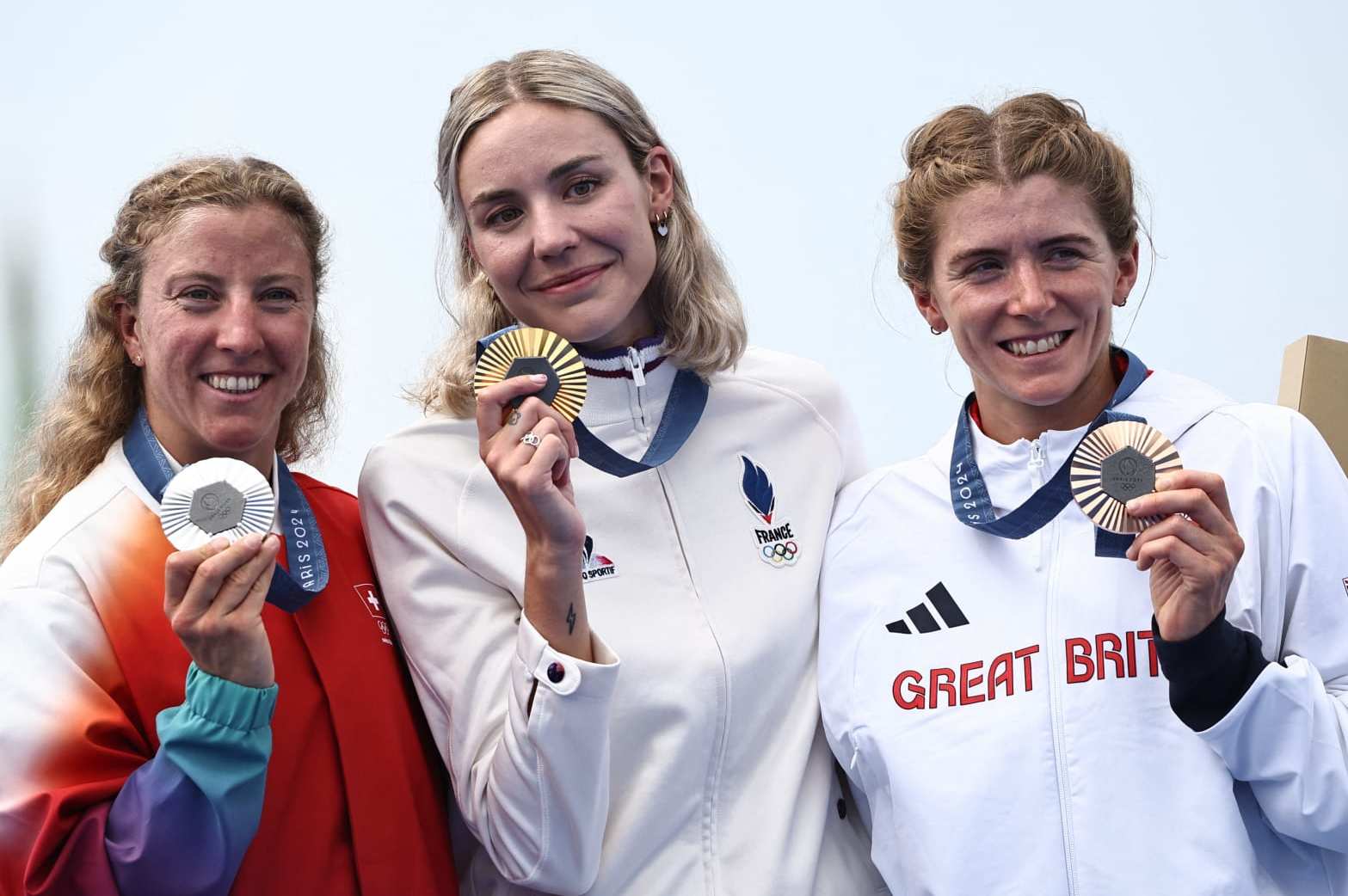 Gold medallist France's Cassandre Beaugrand (C), silver medallist Switzerland's Julie Derron (L) and bronze medallist Britain's Beth Potter pose after the victory ceremony for the women's individual triathlon at the Paris 2024 Olympic Games in central Paris on July 31, 2024. (Photo by Anne-Christine POUJOULAT / AFP) (Photo by ANNE-CHRISTINE POUJOULAT/AFP via Getty Images)