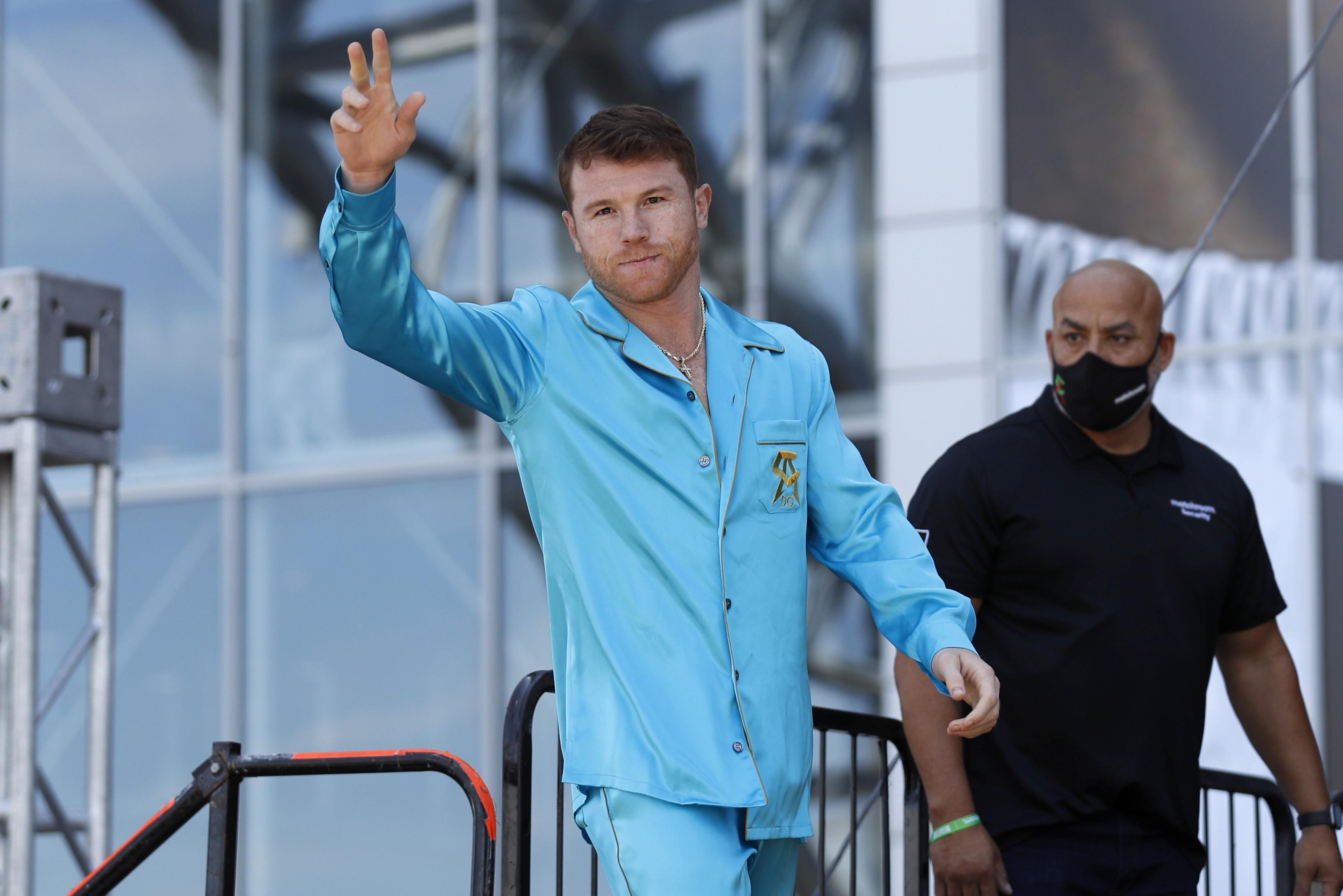 Boxer Canelo Alvarez gestures to the crowd as he walks onto the stage before his weigh-in before his fight with Billy Joe Saunders, Friday, May 7, 2021, in Arlington, Texas. Alvarez and Saunders fight on Saturday, May 8, 2021, for the unified super middleweight world championship. (AP Photo/Roger Steinman)