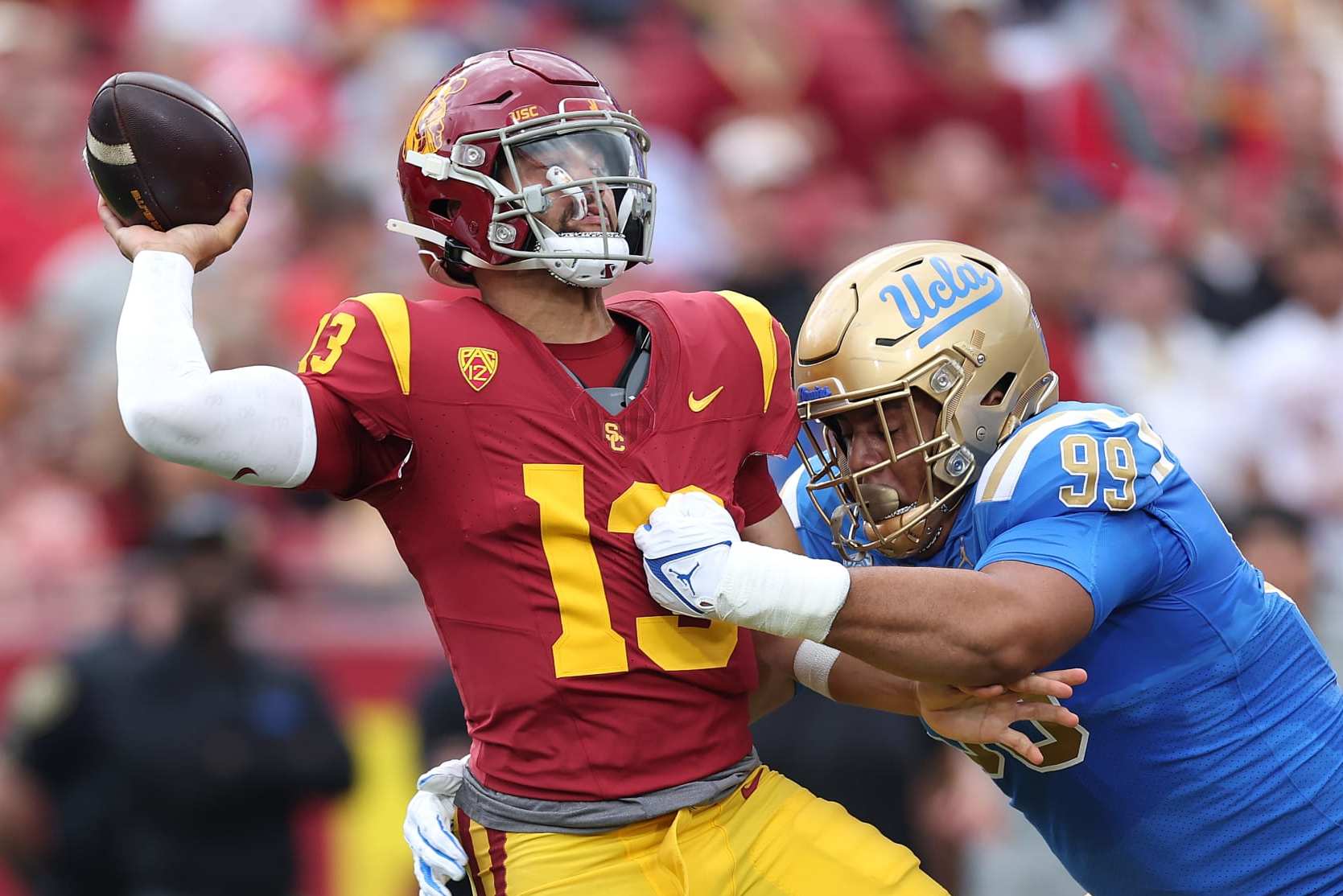 LOS ANGELES, CALIFORNIA - NOVEMBER 18: Keanu Williams #99 of the UCLA Bruins pressures Caleb Williams #13 of the USC Trojans during the first half of a game against the UCLA Bruins at United Airlines Field at the Los Angeles Memorial Coliseum on November 18, 2023 in Los Angeles, California. (Photo by Sean M. Haffey/Getty Images)