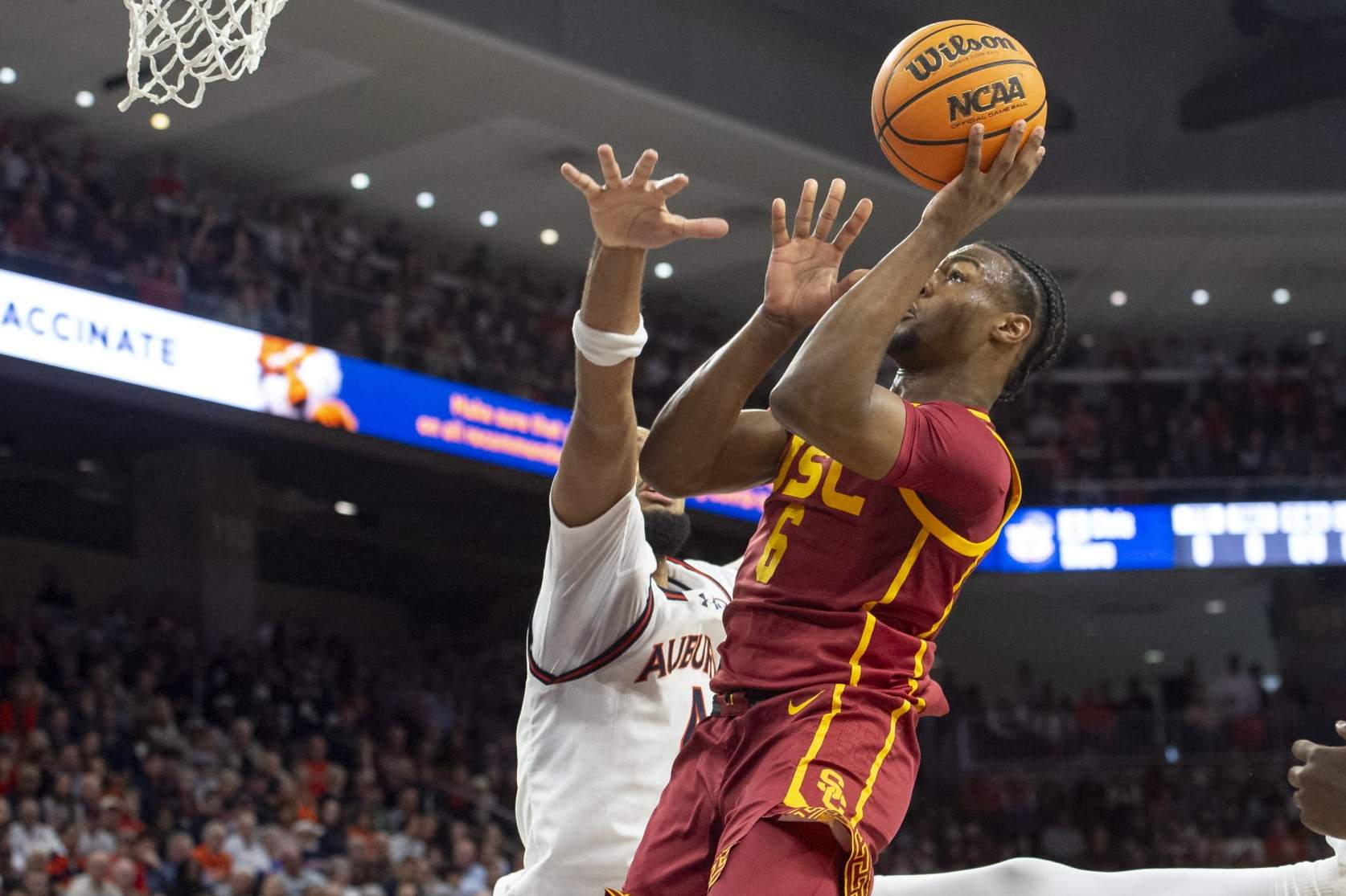 AUBURN, ALABAMA - DECEMBER 17: Bronny James #6 of the USC Trojans looks to attempt a layup in front of Johni Broome #4 of the Auburn Tigers during the first half of play at Neville Arena on December 17, 2023 in Auburn, Alabama. (Photo by Michael Chang/Getty Images)