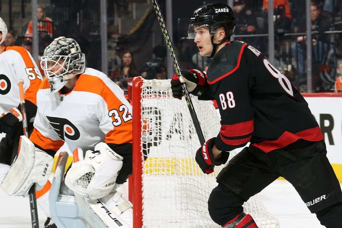 PHILADELPHIA, PENNSYLVANIA - MARCH 18: Martin Necas #88 and Jordan Martinook #48 of the Carolina Hurricanes positioned around the net against Felix Standstrom #32 and Rasmus Ristolainen #55 of the Philadelphia Flyers at the Wells Fargo Center on March 18, 2023 in Philadelphia, Pennsylvania. (Photo by Len Redkoles/NHLI via Getty Images)