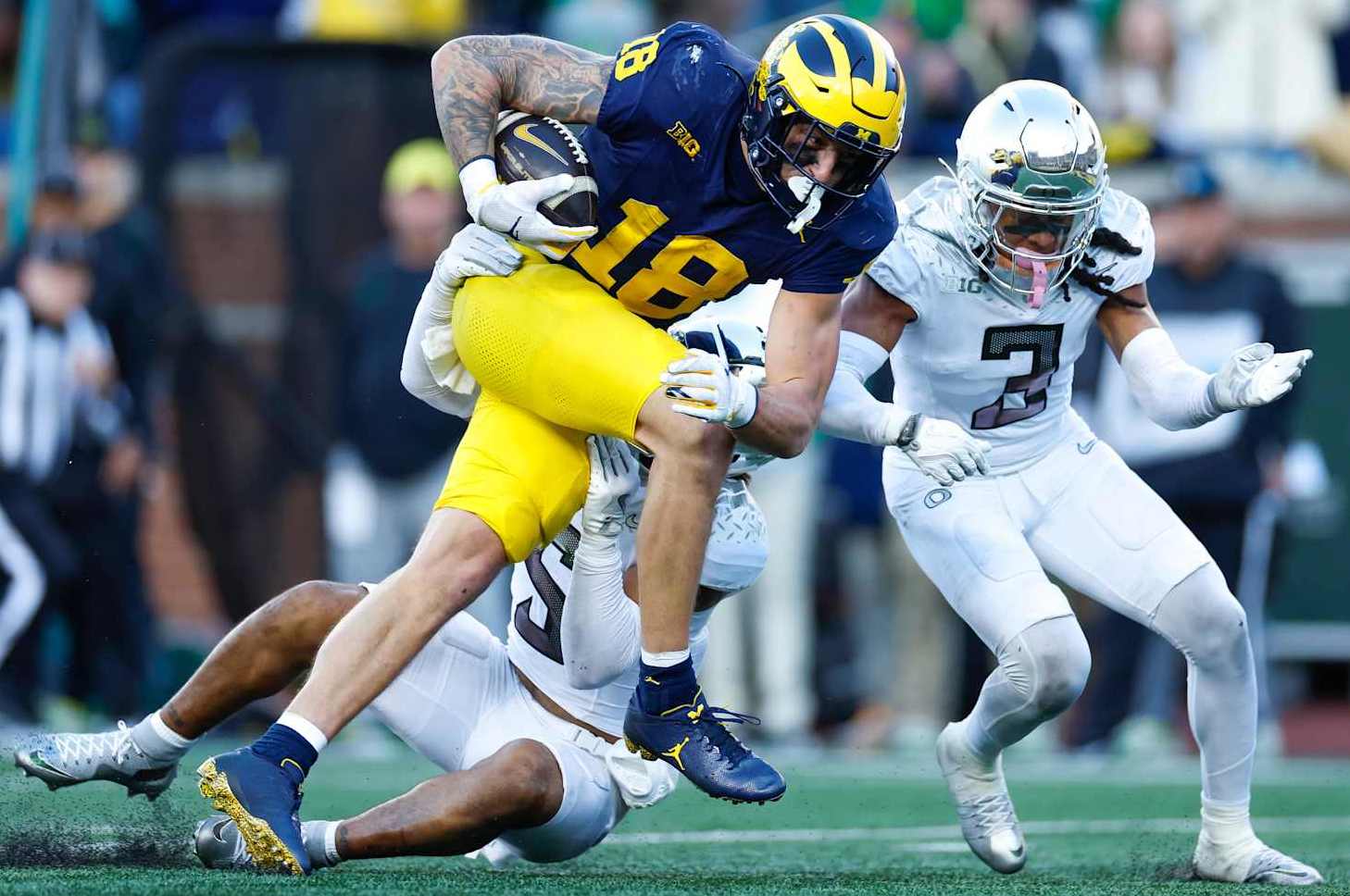 ANN ARBOR, MICHIGAN - NOVEMBER 2: Colston Loveland #18 of the Michigan Wolverines runs after the catch in front of Kobe Savage #5 of the Oregon Ducks and Brandon Johnson #3 during the second half at Michigan Stadium on November 2, 2024 in Ann Arbor, Michigan. (Photo by Brandon Sloter/Image Of Sport/Getty Images)