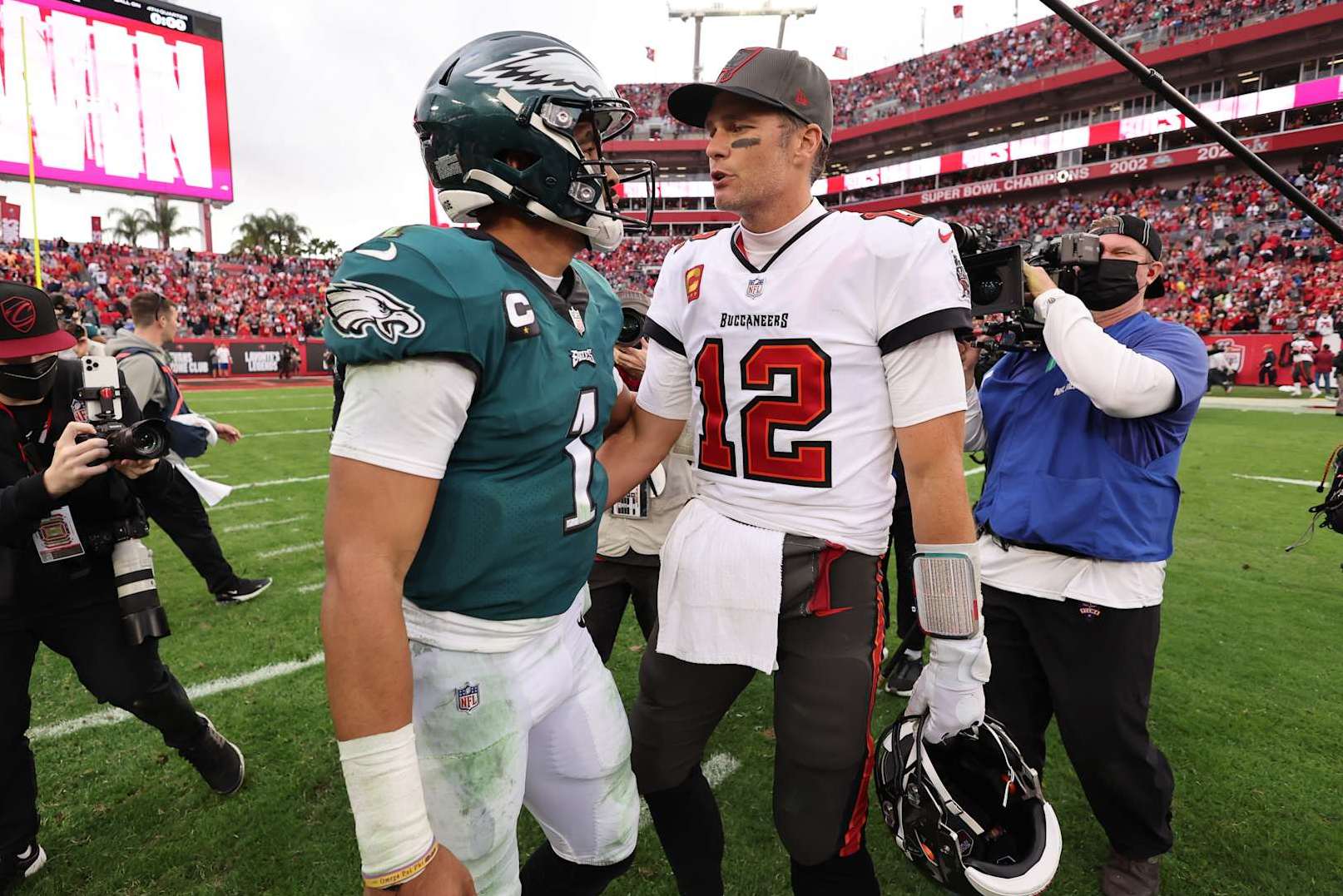 TAMPA, FL - JANUARY 16: Tom Brady #12 of the Tampa Bay Buccaneers and Jalen Hurts #1 of the Philadelphia Eagles talk after the NFC Wild Card playoff game at Raymond James Stadium on January 16, 2022 in Tampa, Florida. (Photo by Perry Knotts/Getty Images)