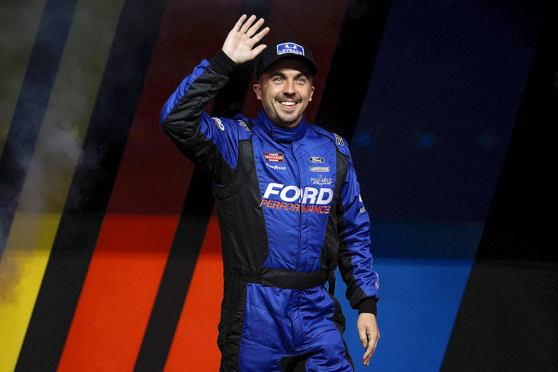 KANSAS CITY, KANSAS - SEPTEMBER 27: Frankie Muniz, driver of the #22 Levrack Ford, waves to fans as he walks onstage during driver intros prior to the NASCAR Craftsman Truck Series Kubota Tractor 200 at Kansas Speedway on September 27, 2024 in Kansas City, Kansas. (Photo by Sean Gardner/Getty Images)