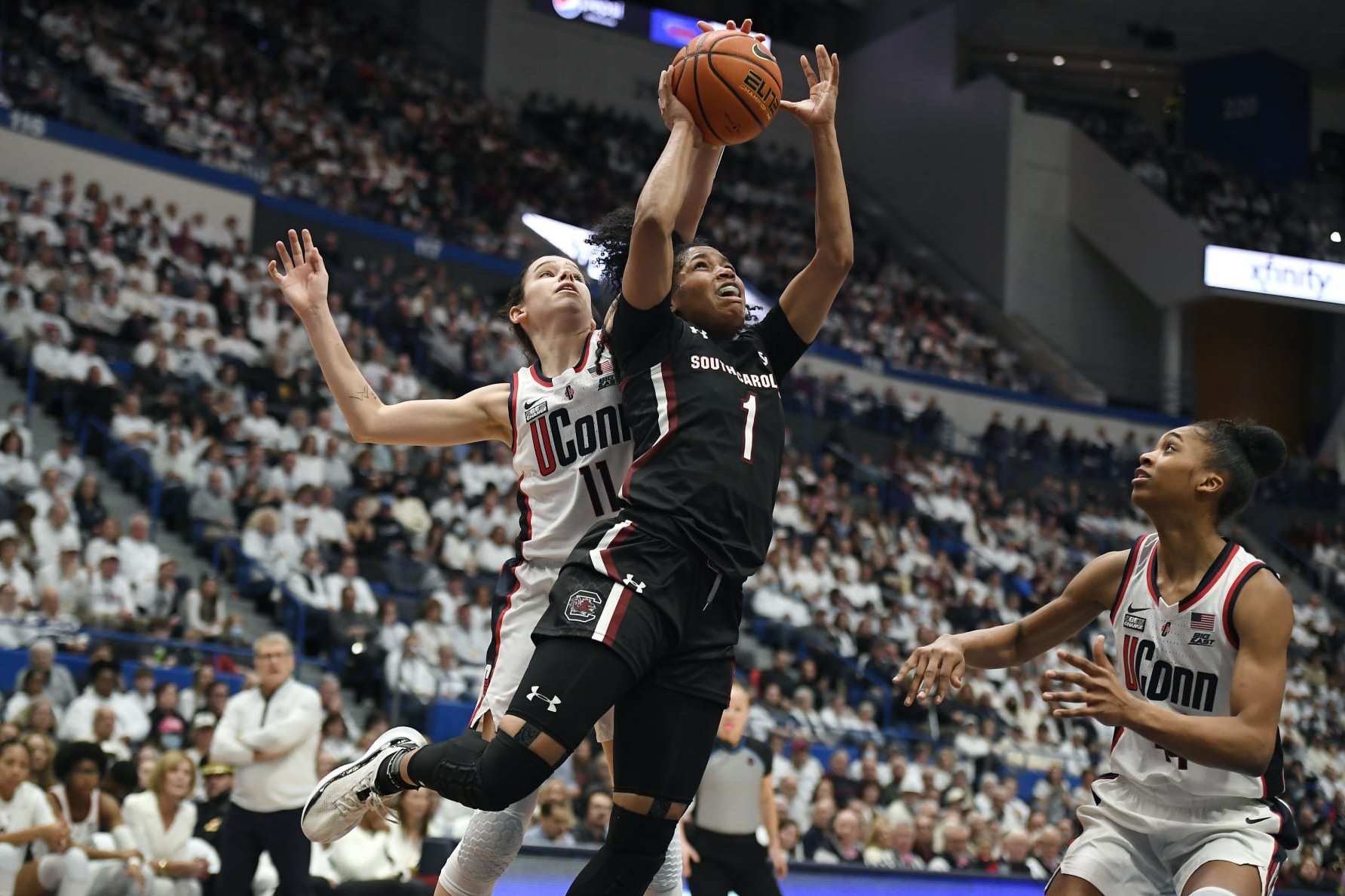 UConn's Lou Lopez-Senechal (11) blocks a shot by South Carolina's Zia Cooke (1) in the first half of an NCAA college basketball game, Sunday, Feb. 5, 2023, in Hartford, Conn. (AP Photo/Jessica Hill)