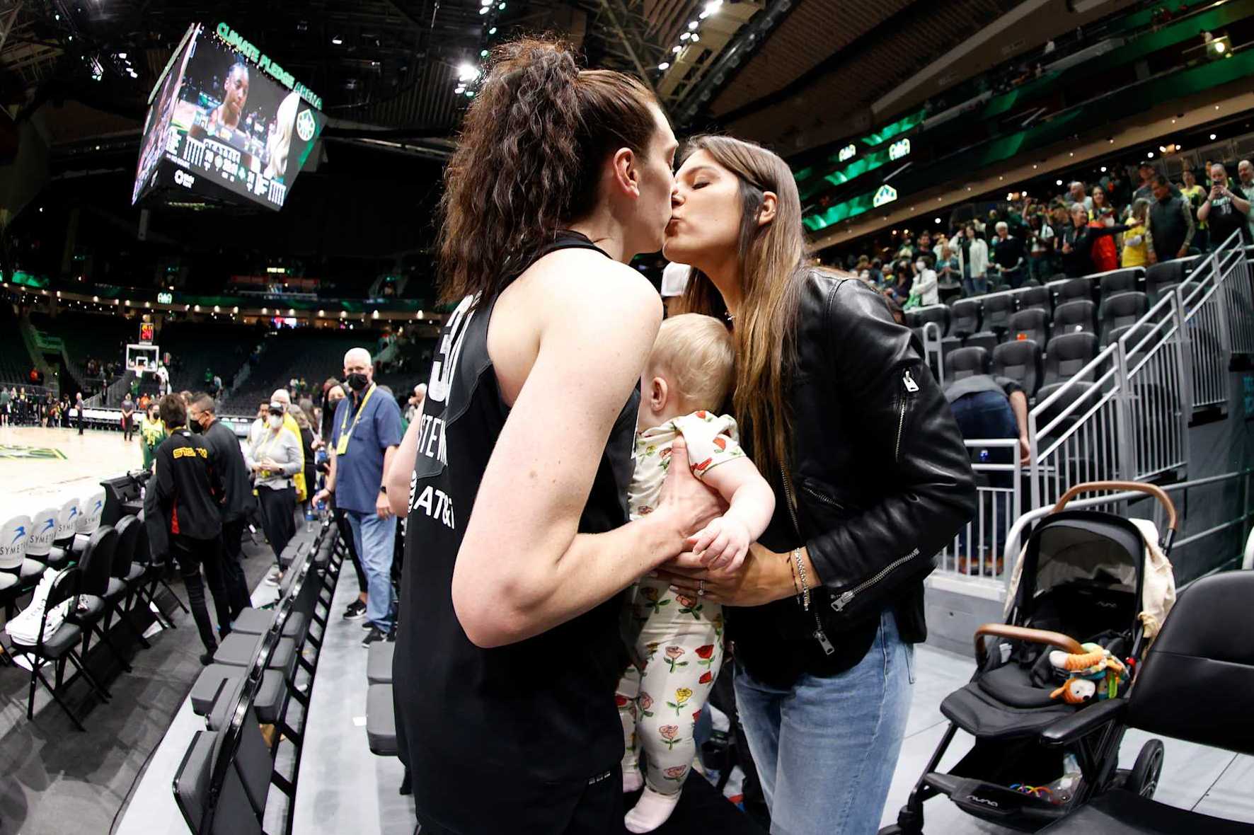 SEATTLE, WASHINGTON - MAY 27: Breanna Stewart #30 of the Seattle Storm kisses her wife Marta Xargay Casademont at Climate Pledge Arena while holding their daughter Ruby Mae Stewart Xargay after the game against the New York Liberty on May 27, 2022 in Seattle, Washington. NOTE TO USER: User expressly acknowledges and agrees that, by downloading and or using this photograph, User is consenting to the terms and conditions of the Getty Images License Agreement (Photo by Steph Chambers/Getty Images)