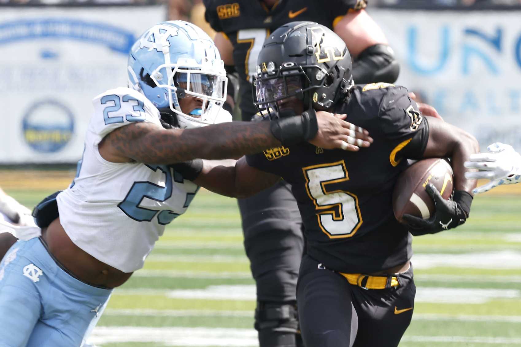 Appalachian State running back Nate Noel (5) runs past North Carolina linebacker Power Echols (23) during the second half of an NCAA college football game, Saturday Sept. 3, 2022, in Boone, N.C. (AP Photo/Reinhold Matay)