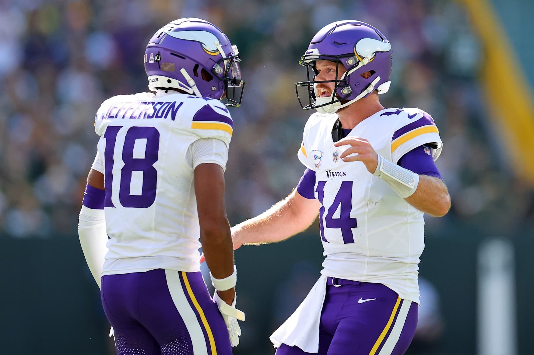GREEN BAY, WISCONSIN - SEPTEMBER 29: Justin Jefferson #18 and Sam Darnold #14 of the Minnesota Vikings celebrate a touchdown against the Green Bay Packers during the first quarter of the game at Lambeau Field on September 29, 2024 in Green Bay, Wisconsin. (Photo by Stacy Revere/Getty Images)